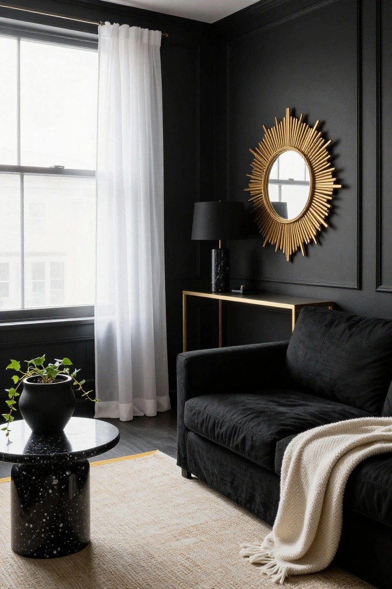 Corner of a black-paneled living room with large gold sunburst mirror above gold console table and black lamp, black velvet sofa with cream throw, potted plant on black terrazzo side table, sheer curtains on window, beige rug on dark floor.
