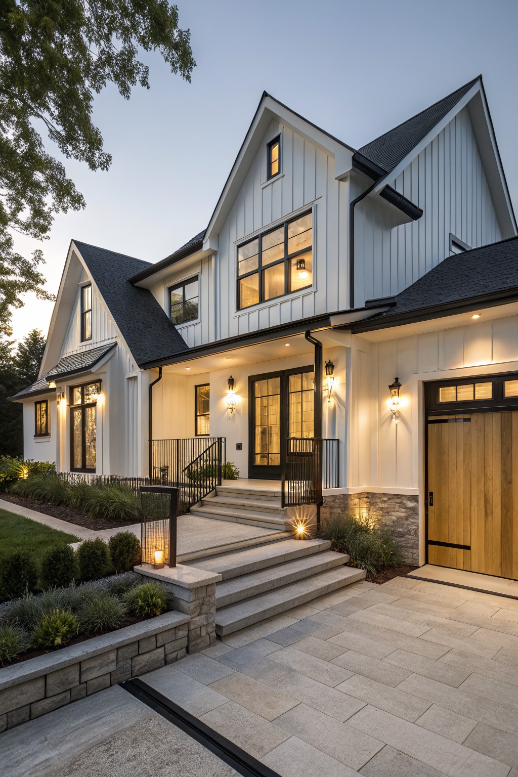 A two-story modern farmhouse exterior with white board-and-batten siding, black-framed windows and doors, dark shingled roof, wooden garage door, stone entry steps with railing, and low landscaping in the front yard at dusk.