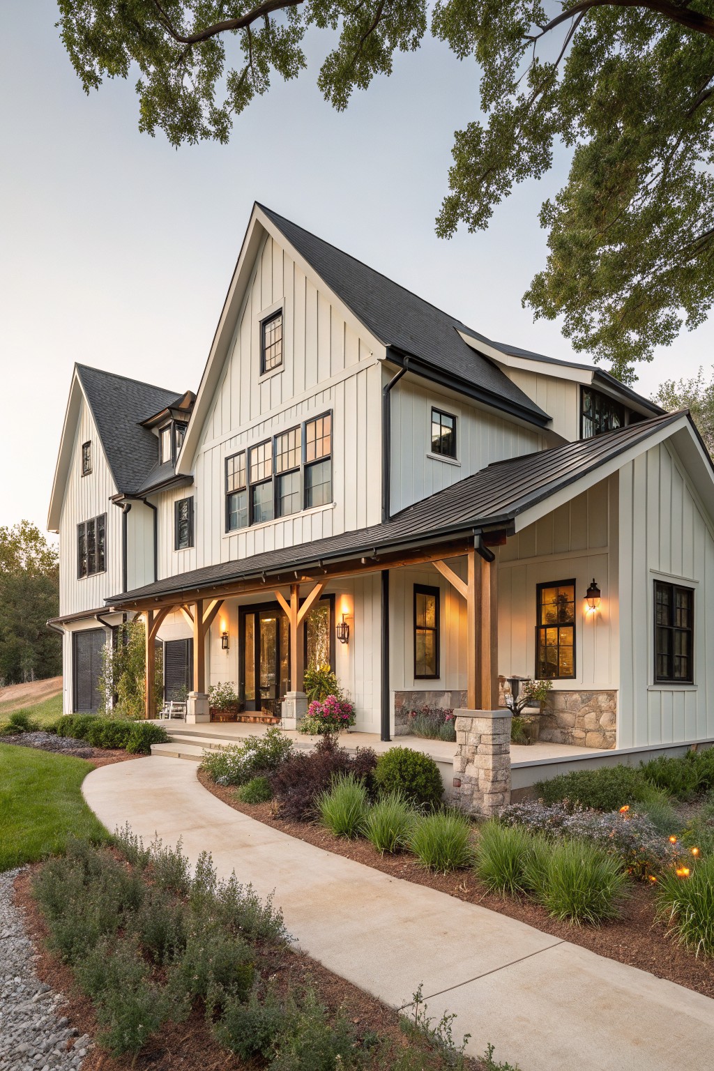 White board-and-batten sided modern farmhouse with dark metal gabled roofs, black window trim, covered front porch with wood beams and stone accents, curved concrete walkway, and low landscaping.