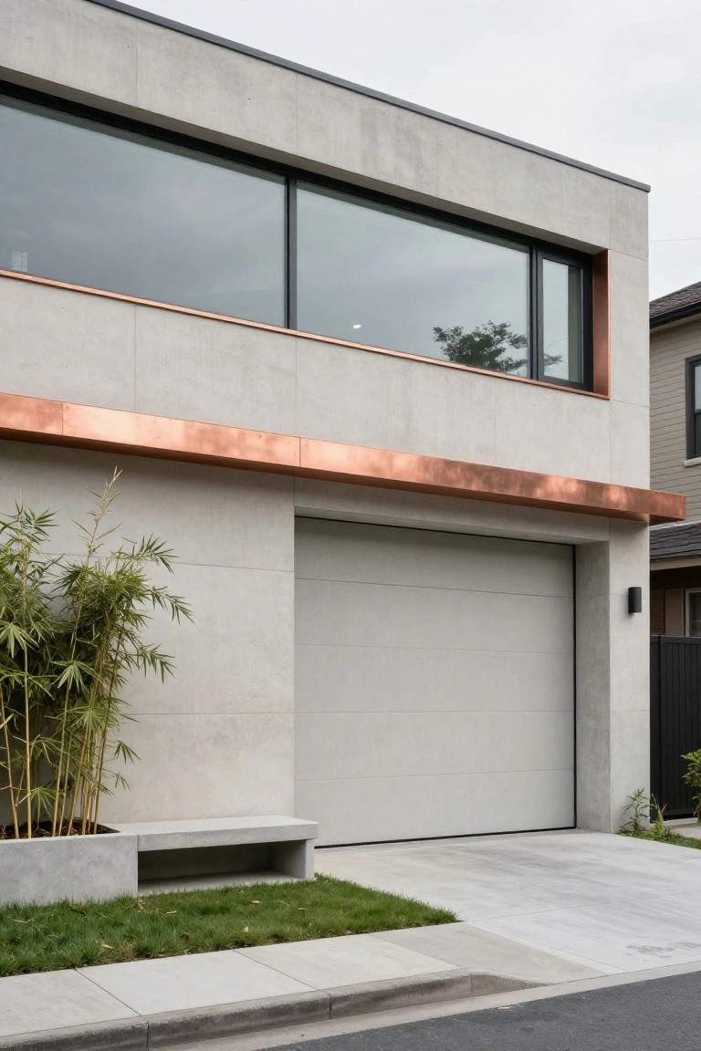 Modern two-story house exterior with gray concrete walls, copper trim above large horizontal window and garage door, bamboo plants in concrete planter with bench, and small grass patch.