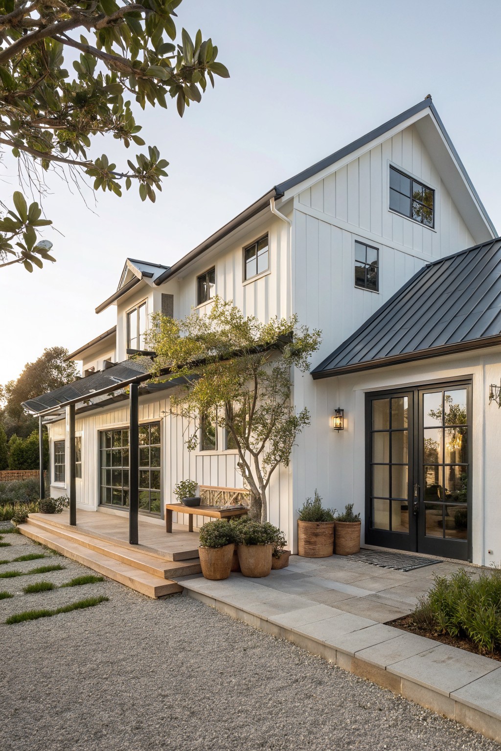 Modern white farmhouse with black metal roof and wooden porch.