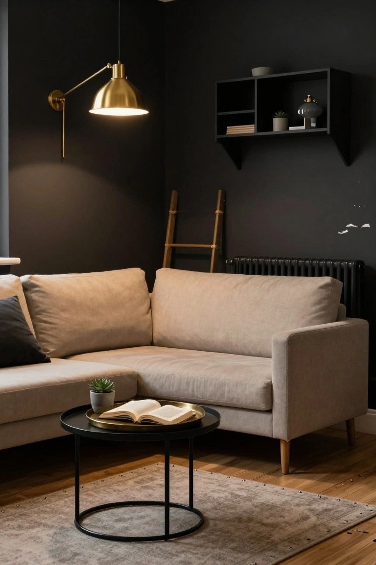 Corner of a dark-walled living room with beige L-shaped sofa, black metal coffee table on a beige rug, gold wall lamp, wooden ladder leaning nearby, and black radiator.