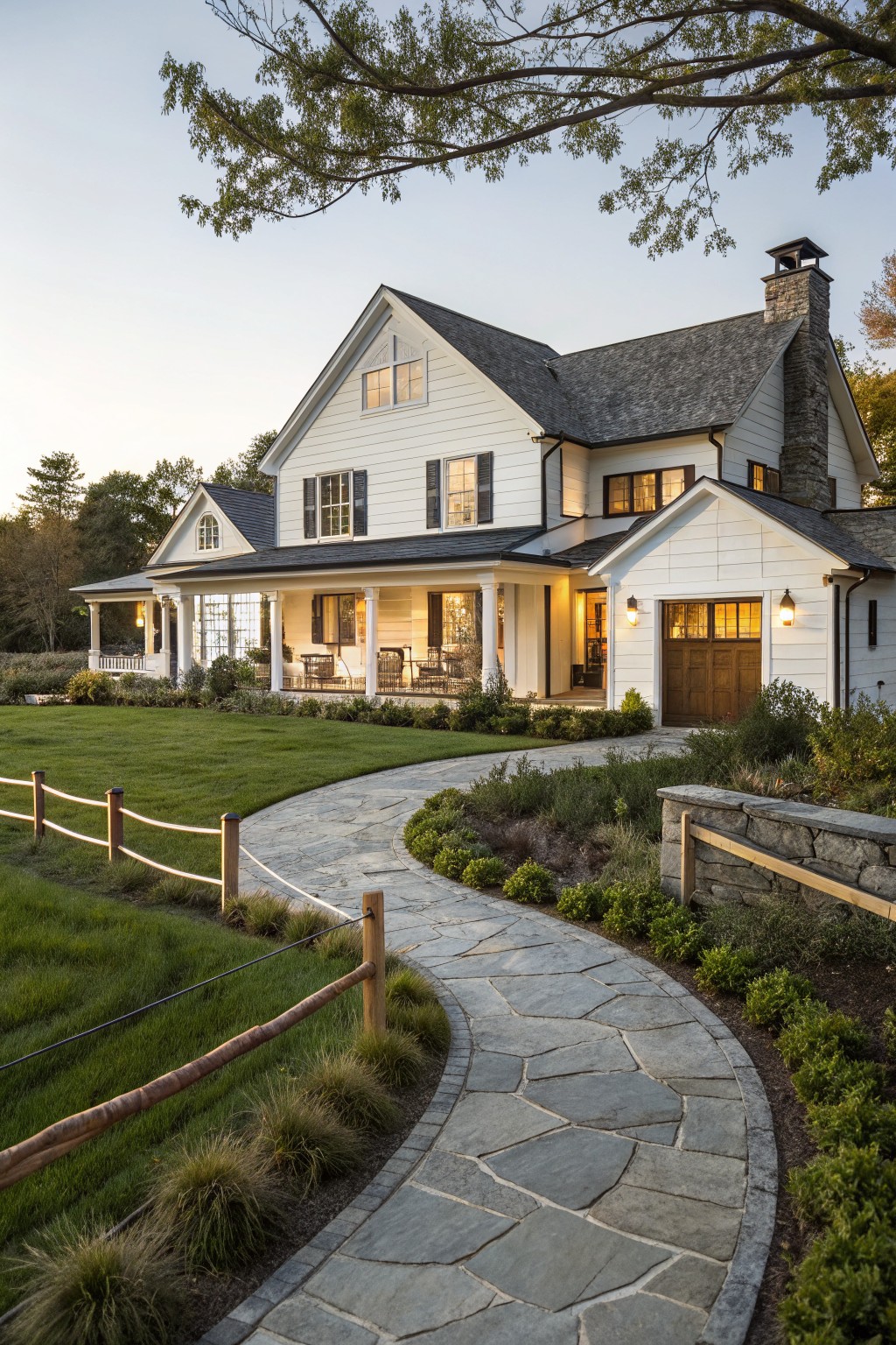 A white two-story farmhouse with a wide front porch and a curving flagstone path leading through a grassy yard.