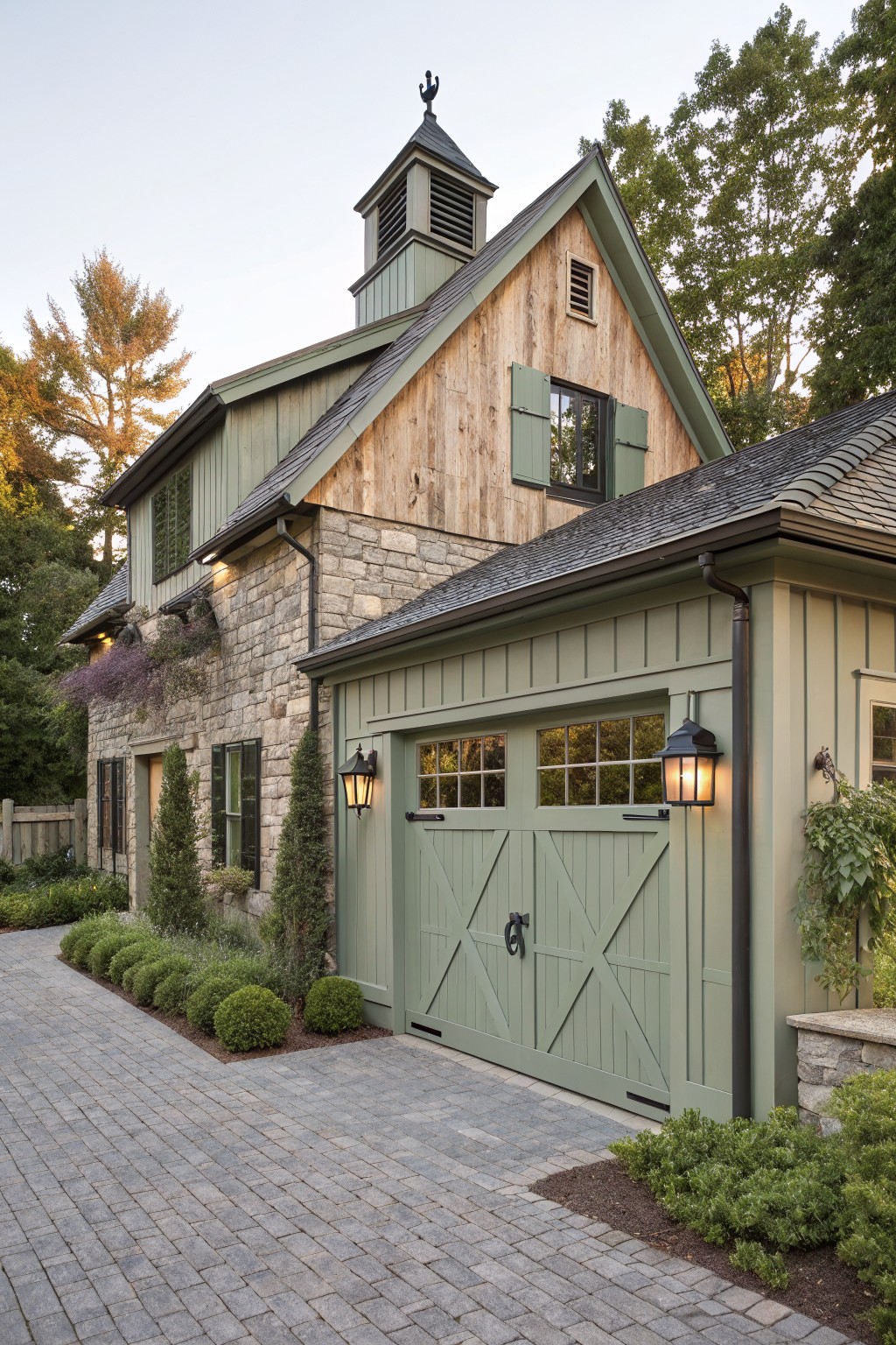 Green wooden garage doors on stone and wood house with cobblestone drive.