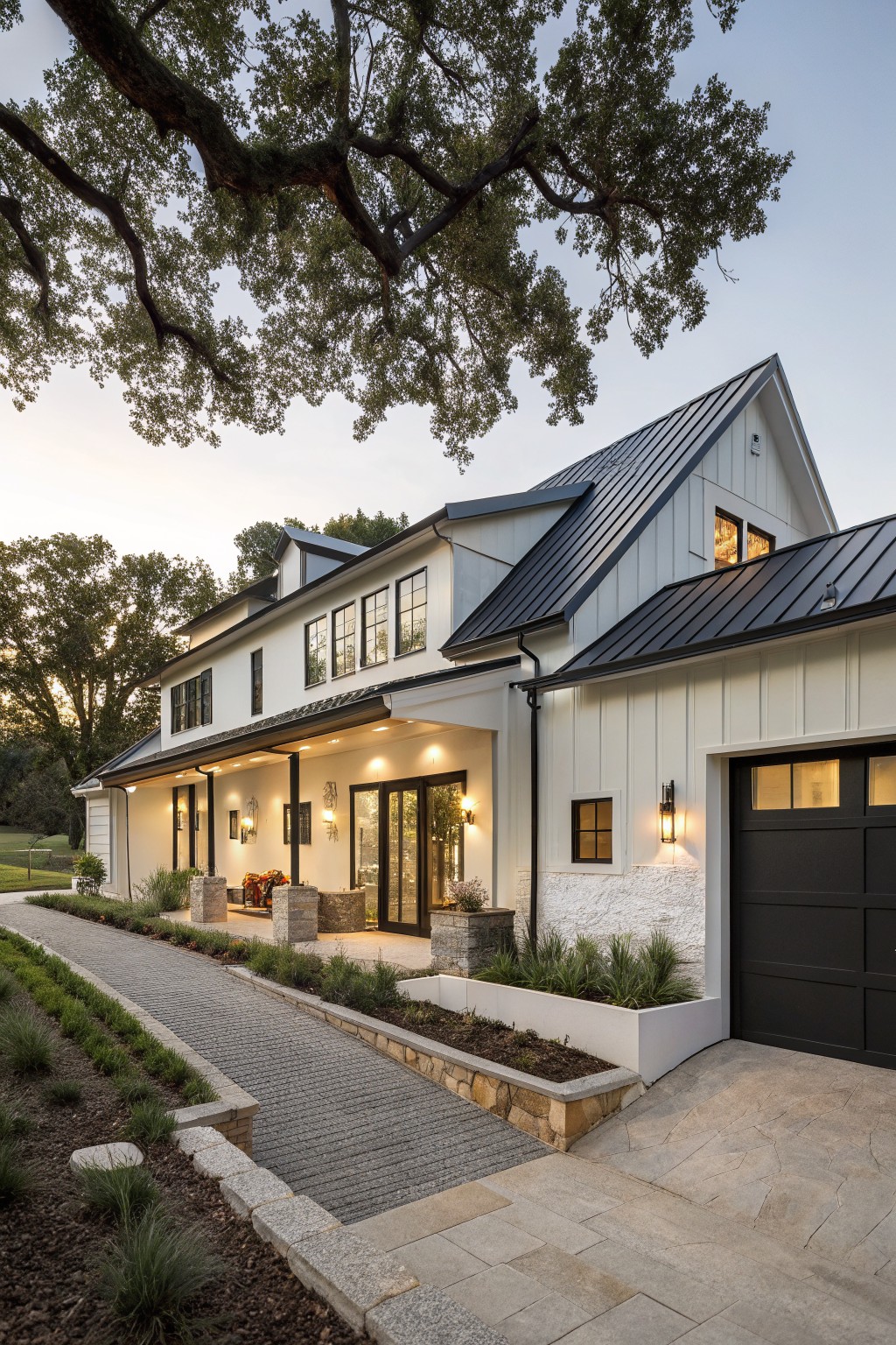 A white modern farmhouse with black metal roof, black windows, and black garage door viewed from the front driveway.