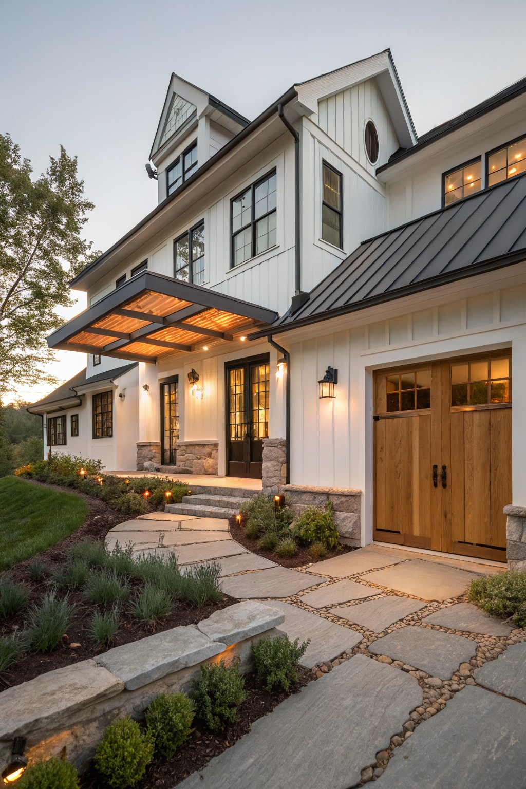 Modern farmhouse exterior with white siding, stone accents around the entry and garage, dark metal roof, wooden garage doors, and a stone pathway with lighting.