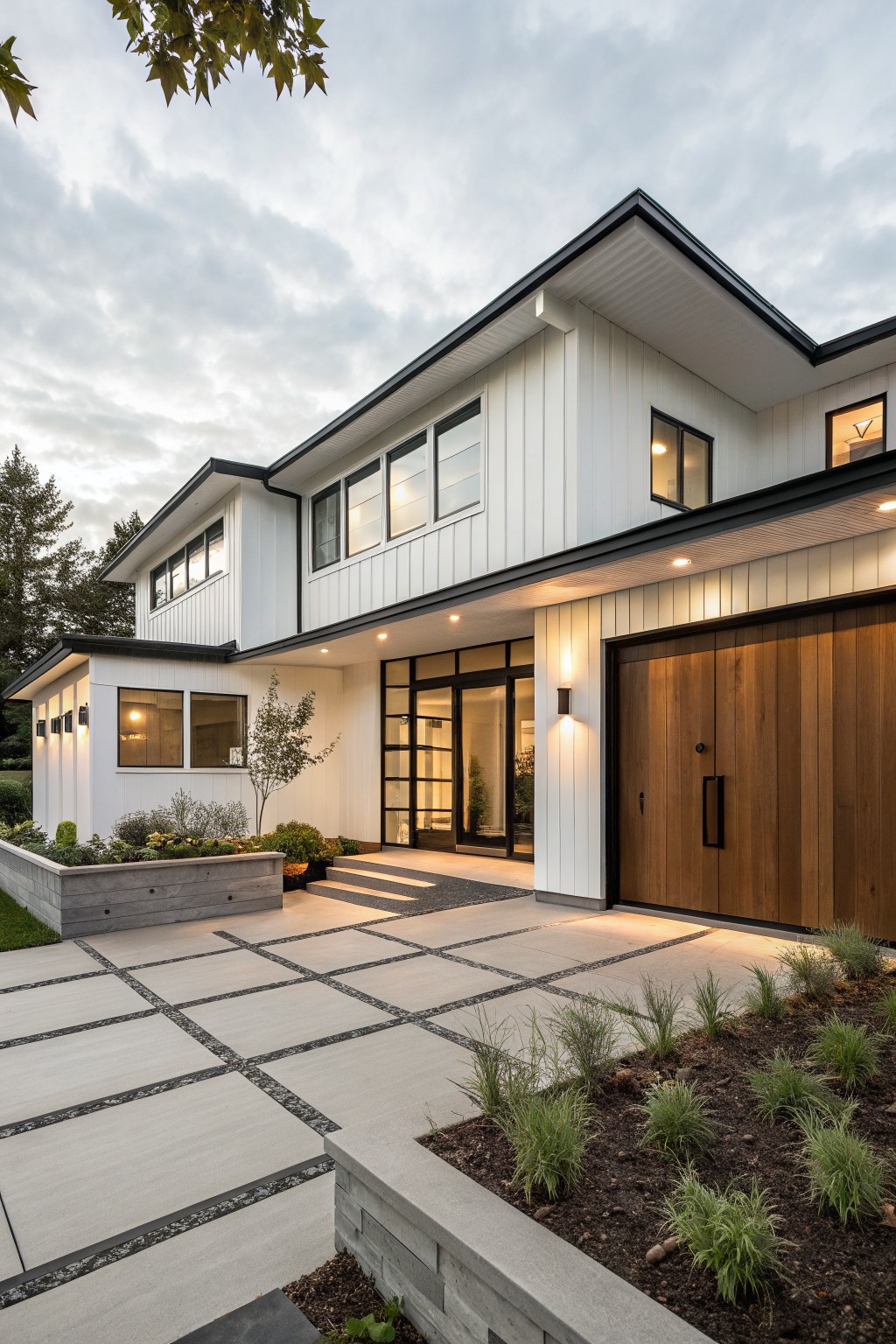 A modern two-story farmhouse exterior with white vertical siding, black trim, a large wooden garage door, and a concrete driveway with grass plantings.