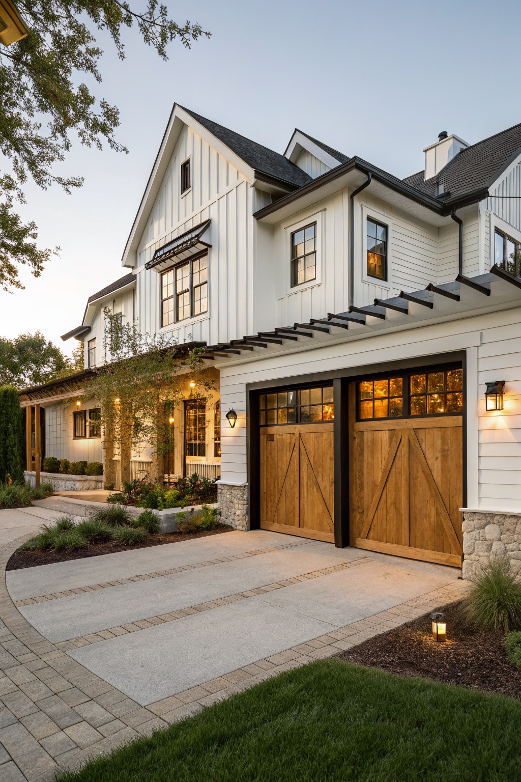 White farmhouse exterior with wooden garage doors set into the facade and a concrete driveway in front.