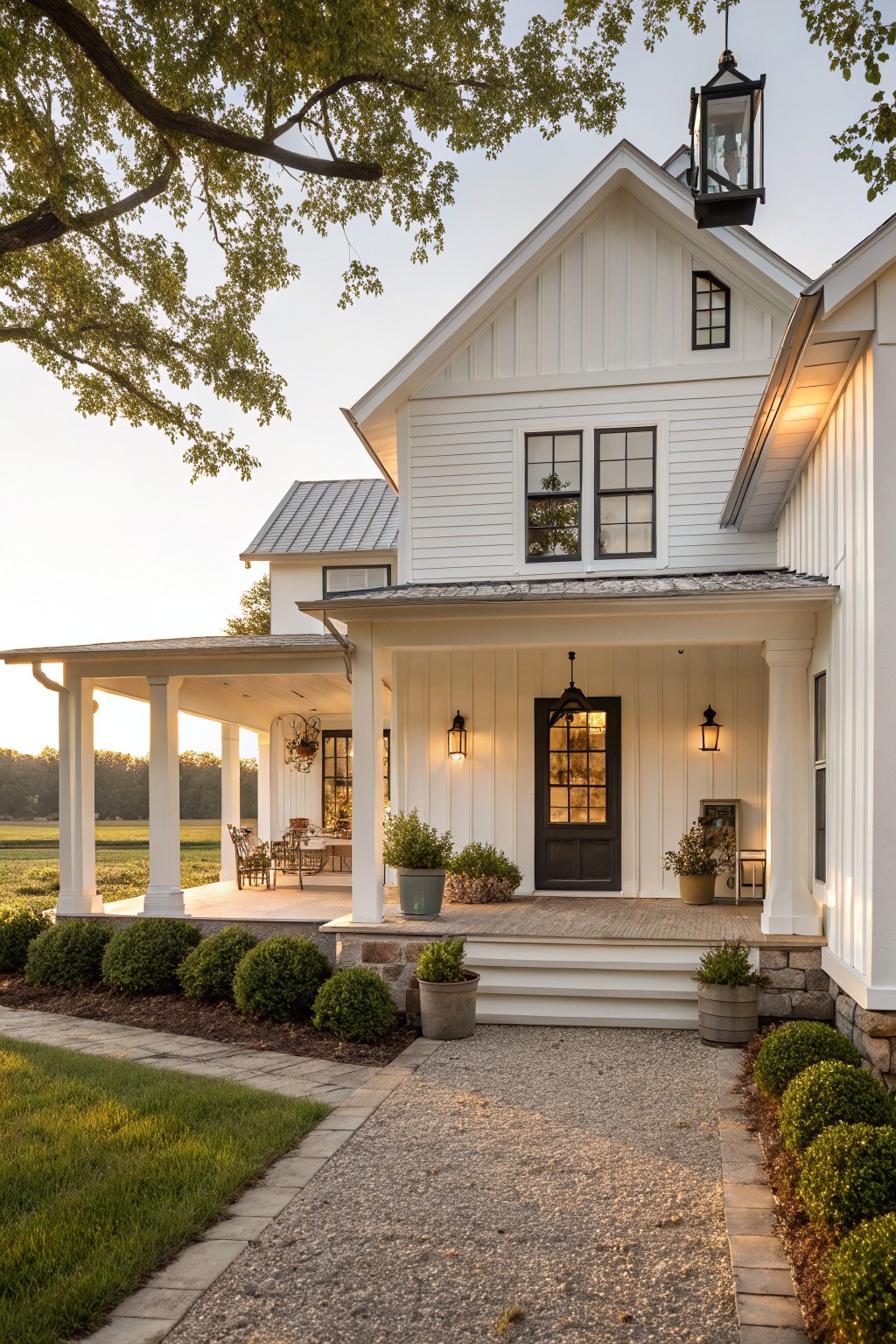 A white two-story farmhouse with a dark front door, covered porch supported by white columns, and stone foundation.