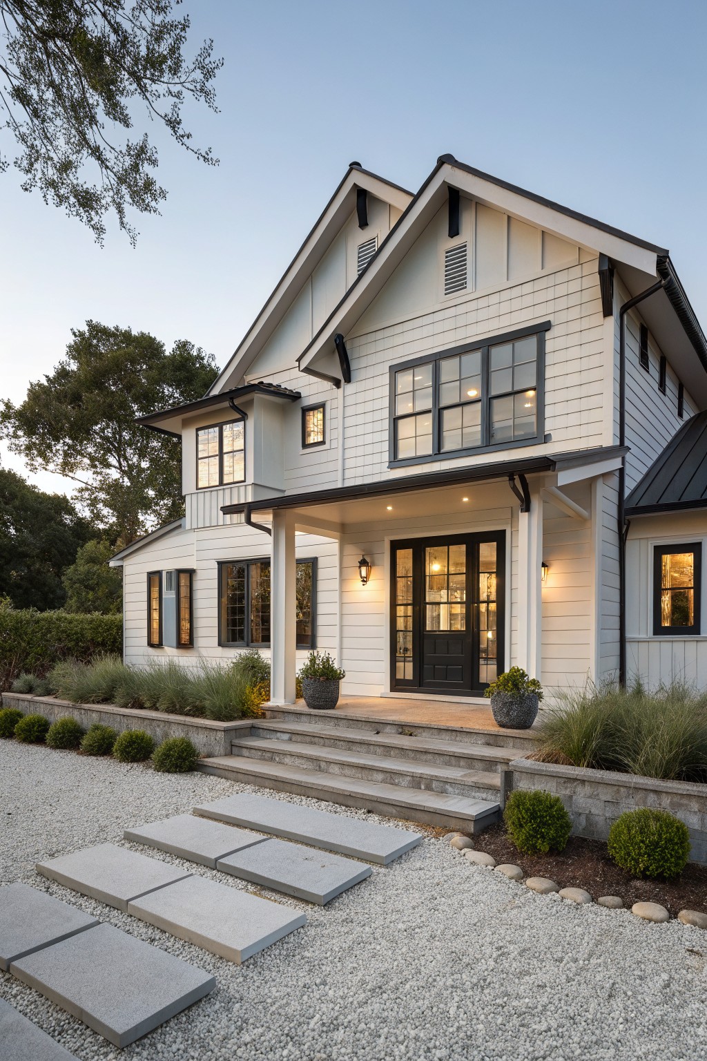 A white two-story farmhouse exterior with black trim on windows and doors, a covered front porch with steps, and a gravel path with concrete stepping stones.