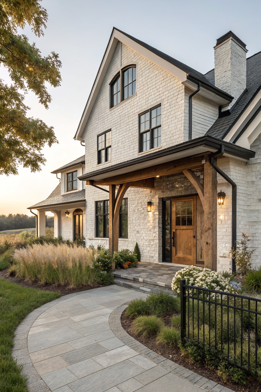 A white shingled farmhouse with a timber-framed porch, wooden front door, and black-trimmed windows.