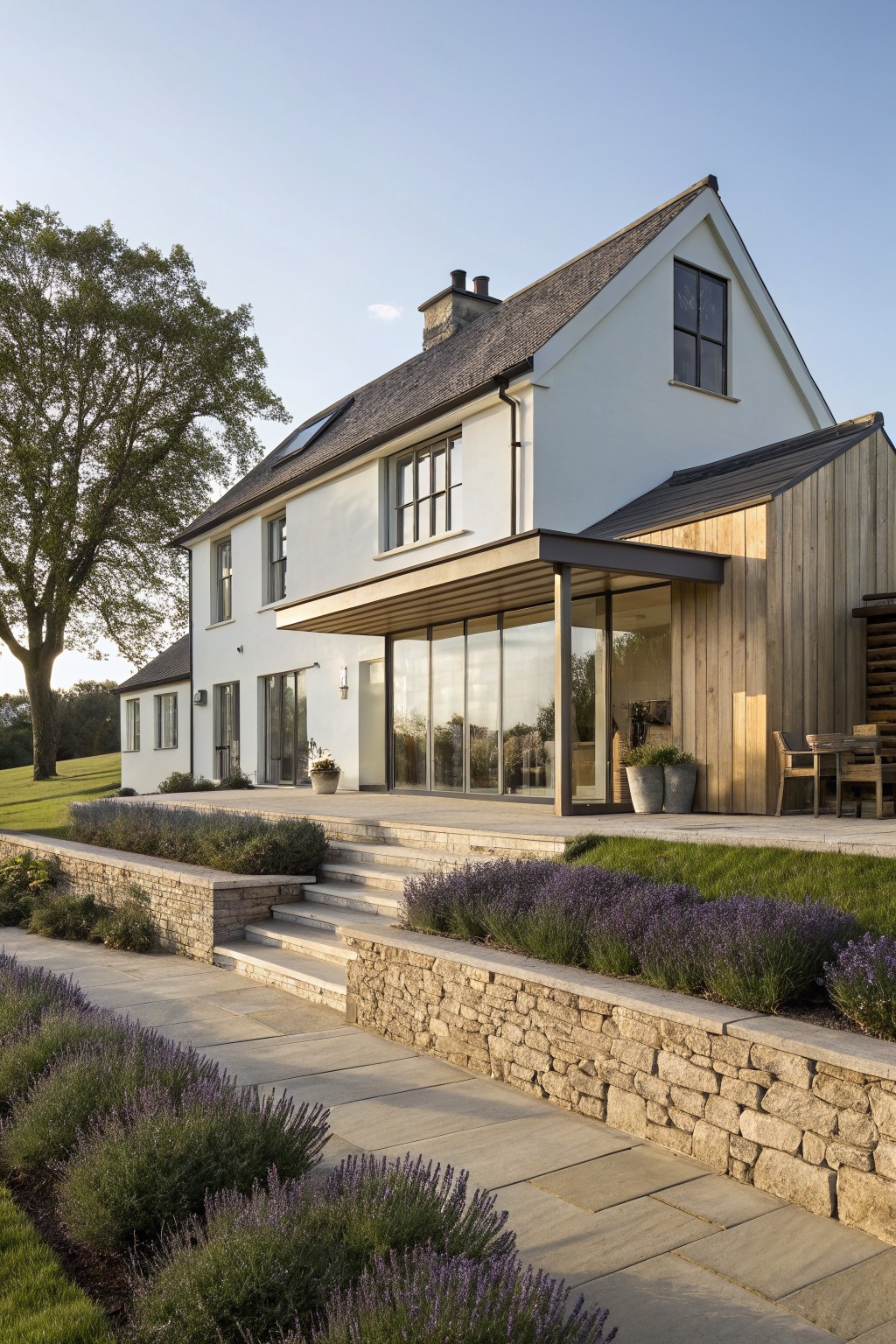 Modern white house with glass doors, wooden extension, stone steps and lavender garden.