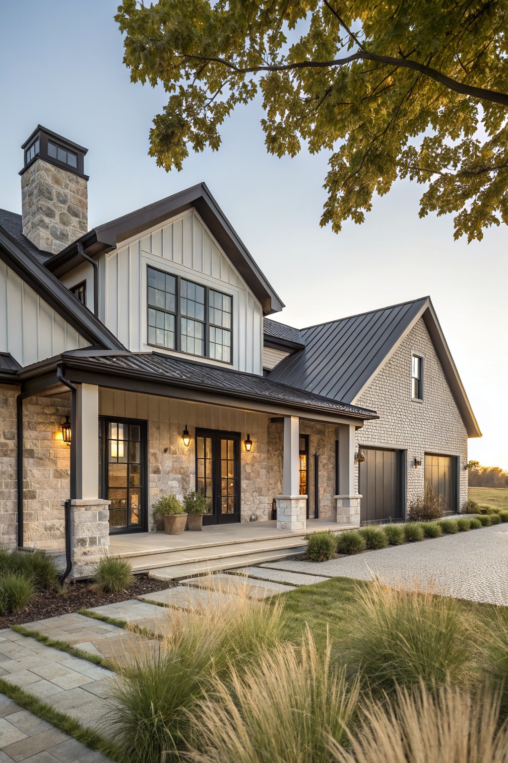 Modern farmhouse with stone exterior, black windows, porch, and lush landscaping