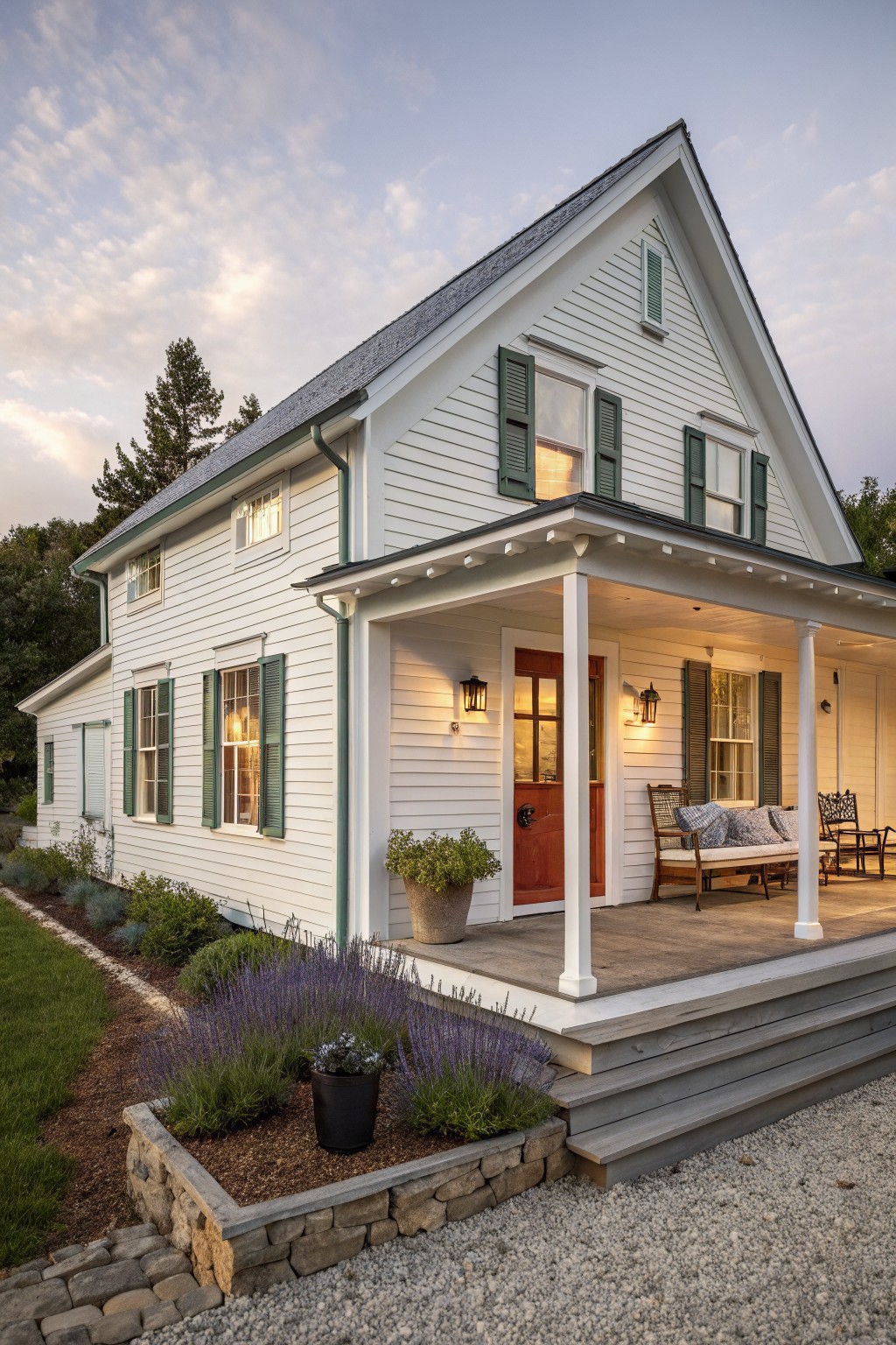 A white two-story farmhouse with green shutters, a gabled roof, and a covered front porch with steps.
