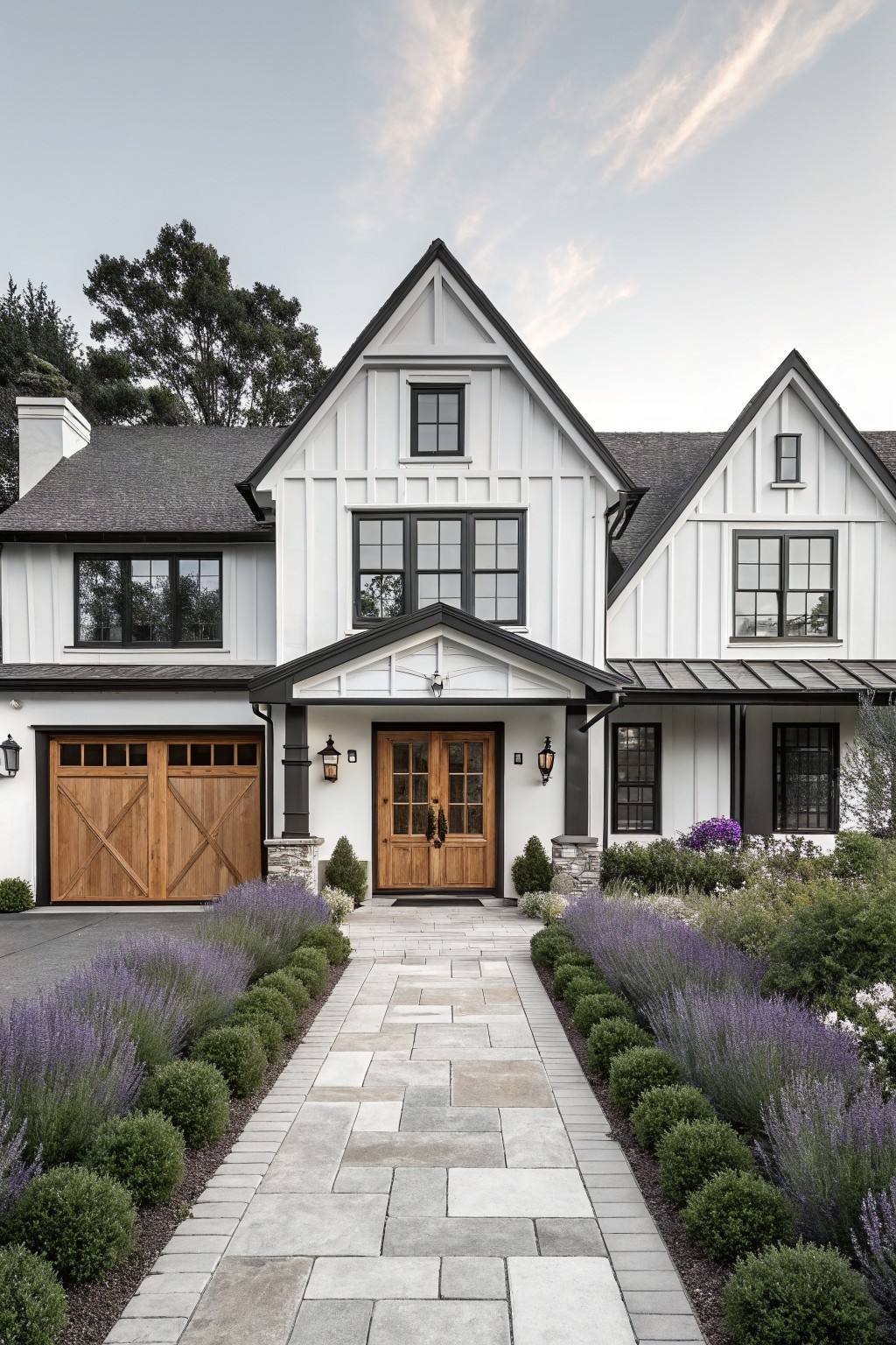 White two-story house with black trim, wooden door, and lavender-lined stone path.