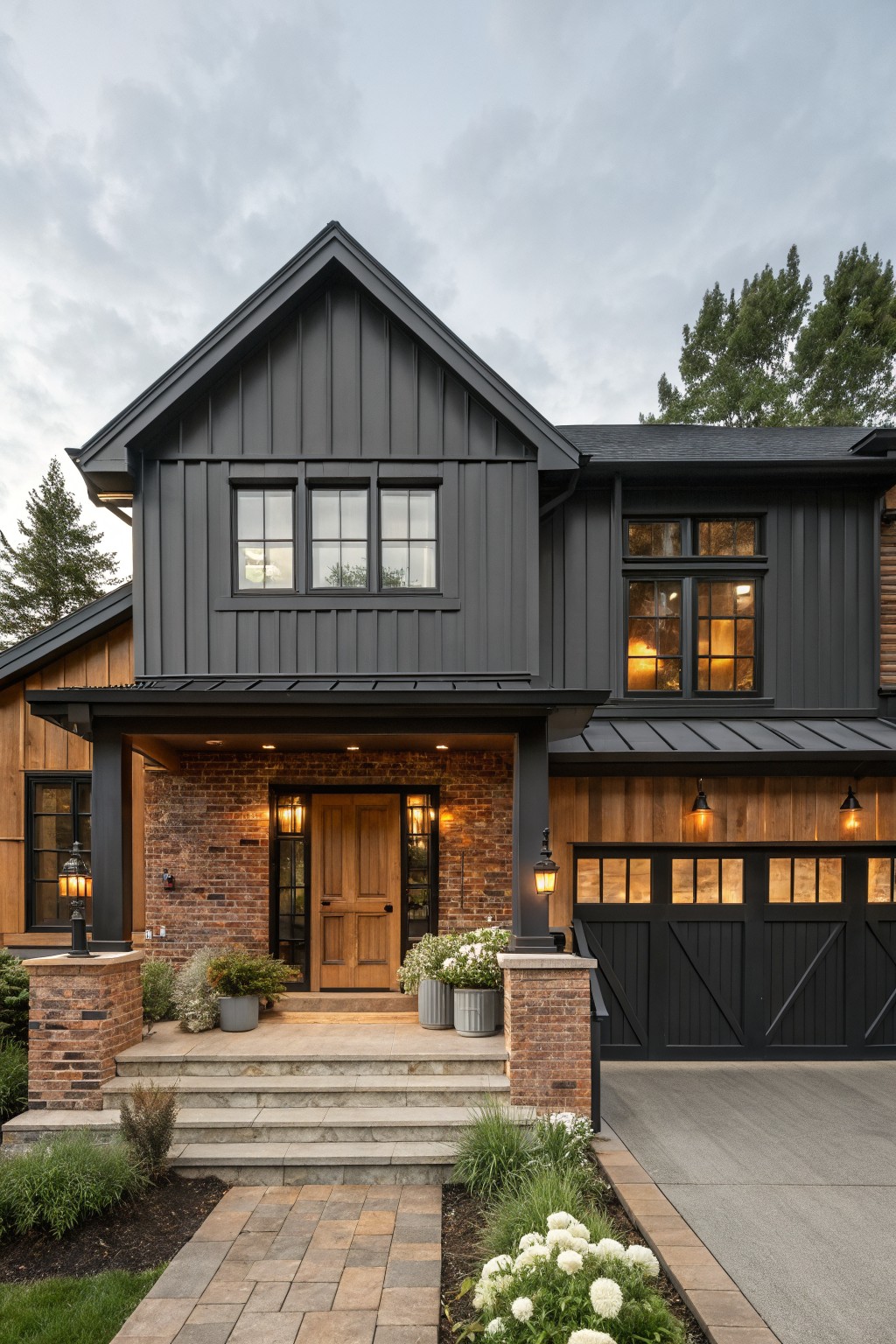 A two-story house with dark board and batten siding, brick around the front door, and a black garage door on the right.
