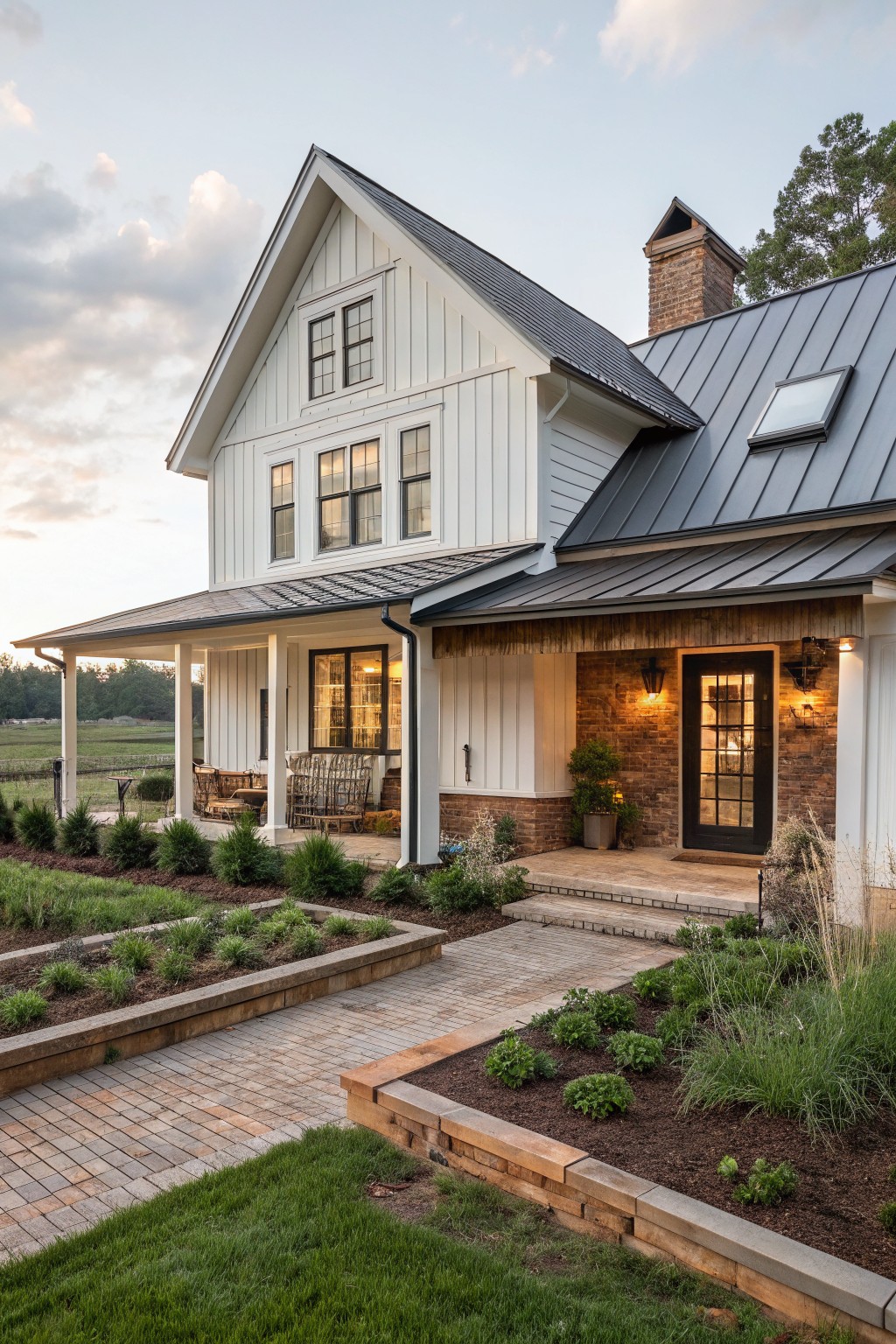 White farmhouse with black metal roof, brick accents, porch, and garden beds.