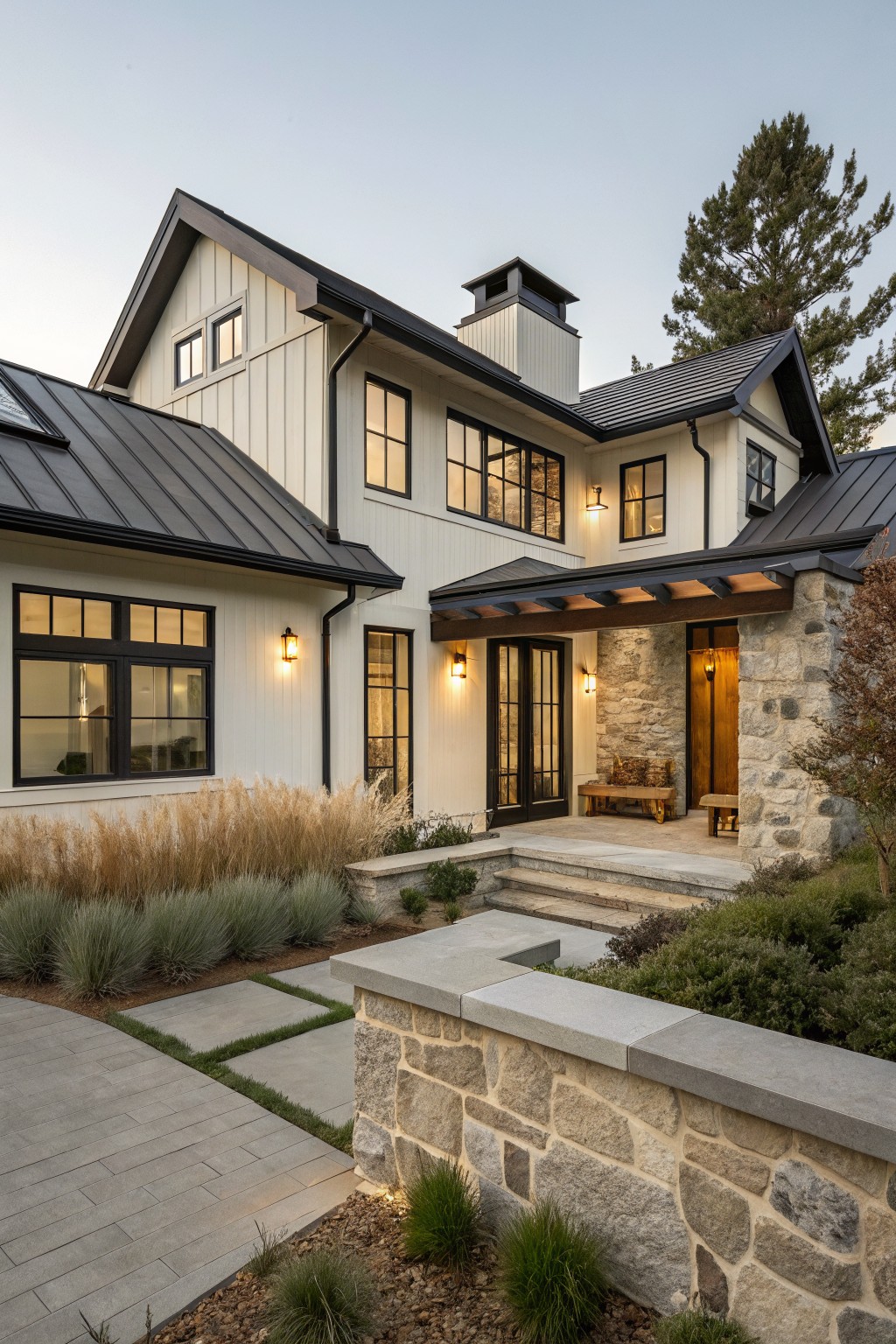 A two-story modern farmhouse with white board and batten siding, a black metal roof, black window frames, and a stone entry porch.