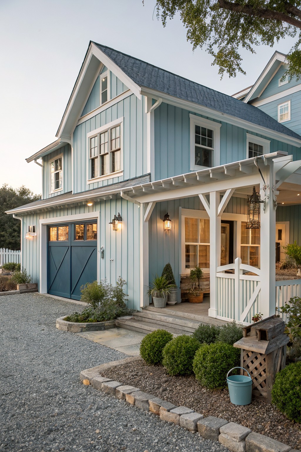 A light blue two-story house with white trim, a dark blue garage door on the left, and a covered front porch with white railings.