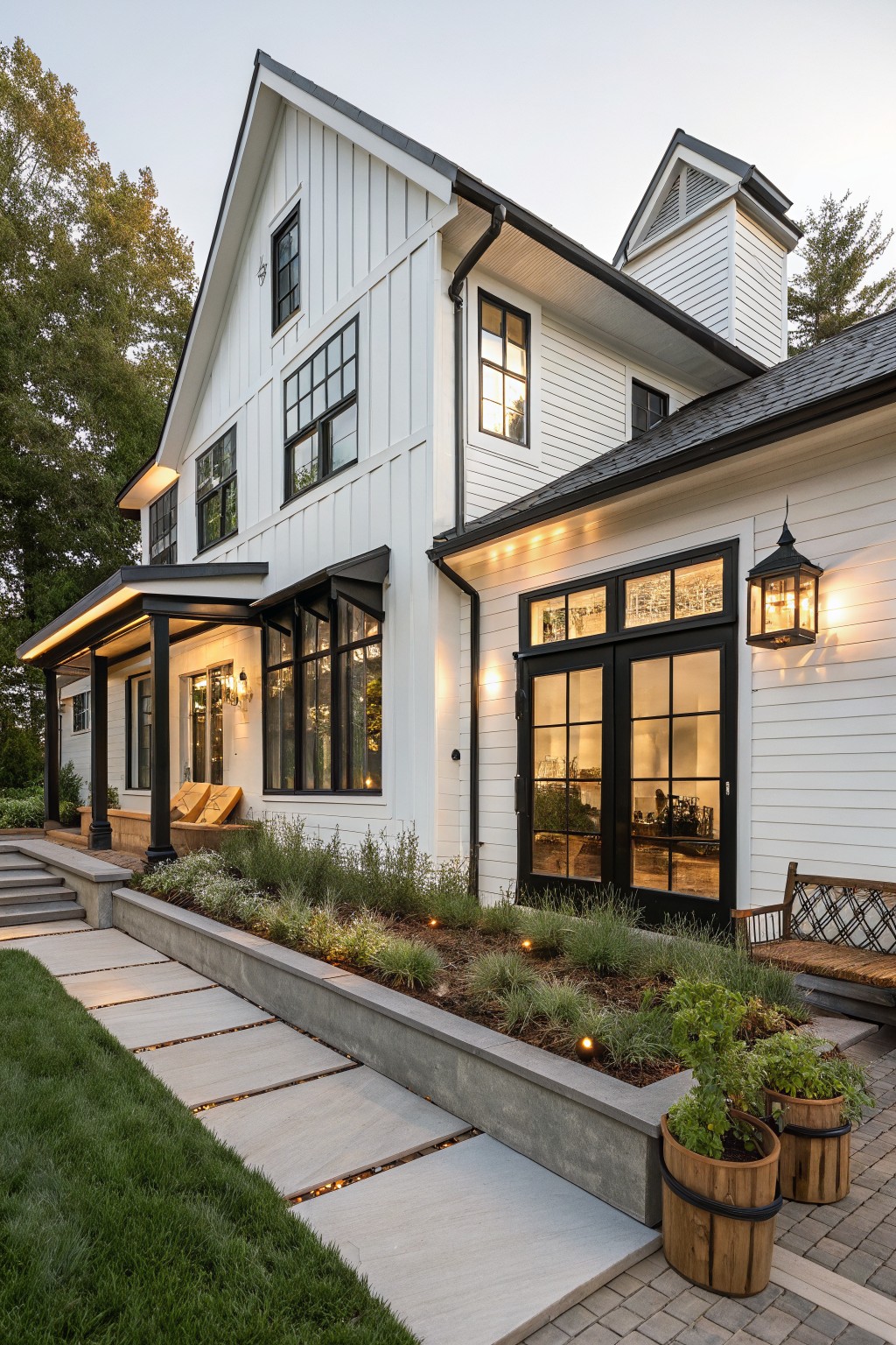 A white two-story farmhouse exterior with black-framed windows and doors, vertical siding, and a concrete pathway leading to the front.