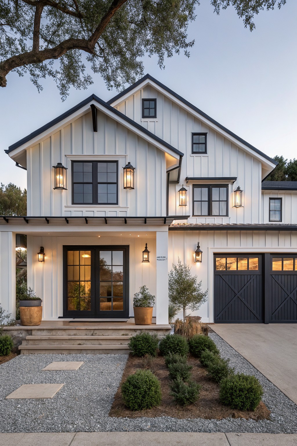 A two-story white house with black window frames, black double front doors, black garage doors, and landscaping in the foreground.