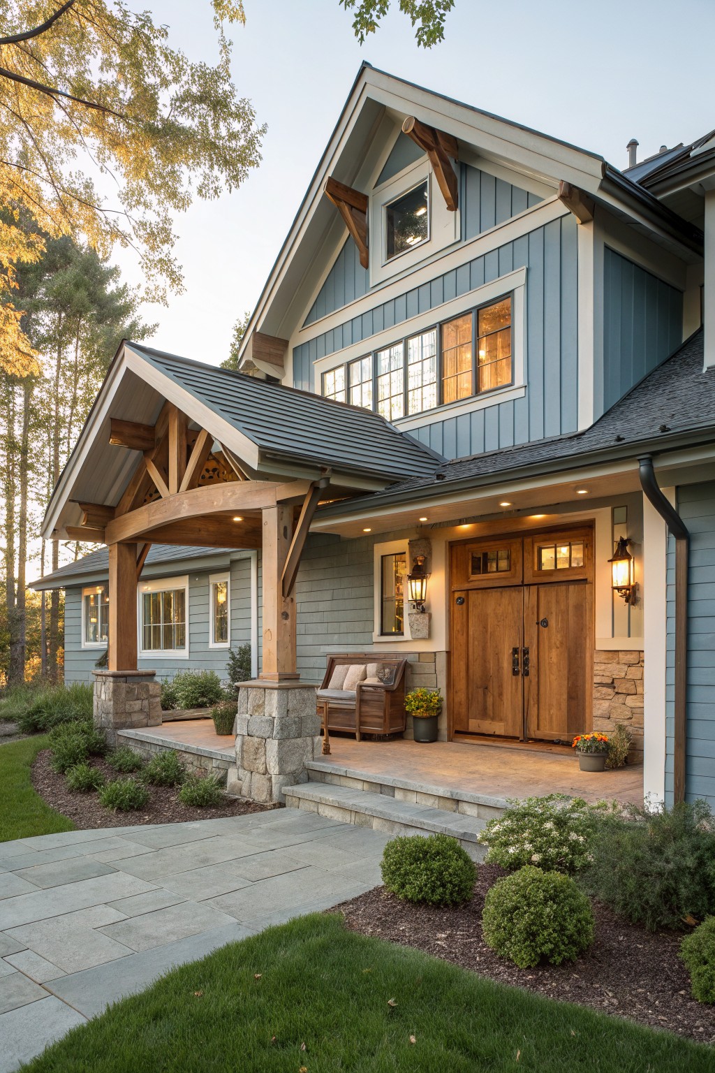 A blue siding house with a covered front porch supported by large wooden beams on stone pillars, double wooden doors, and landscaped entry steps.
