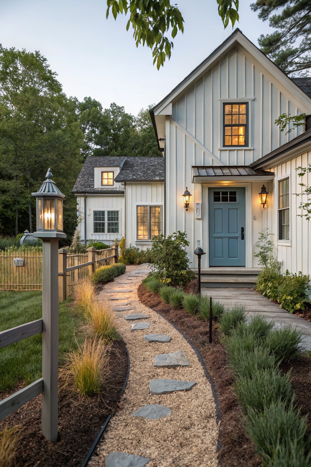 White board and batten farmhouse exterior with light blue front door, stone pathway, and gravel landscaping.