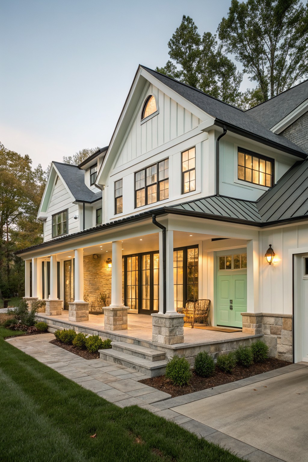 Front view of a two-story white farmhouse with board and batten siding, a covered porch supported by white columns on stone bases, and a mint green front door.