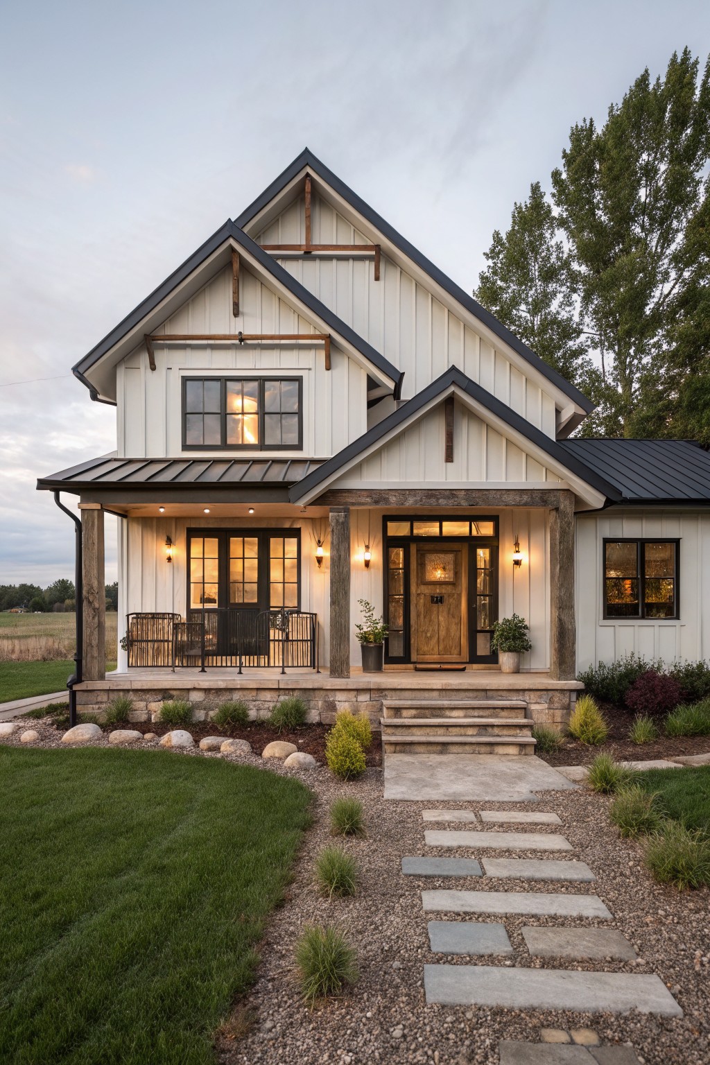 A two-story white board and batten farmhouse exterior with black roof trim, a wooden front door, and a covered porch supported by wooden posts.