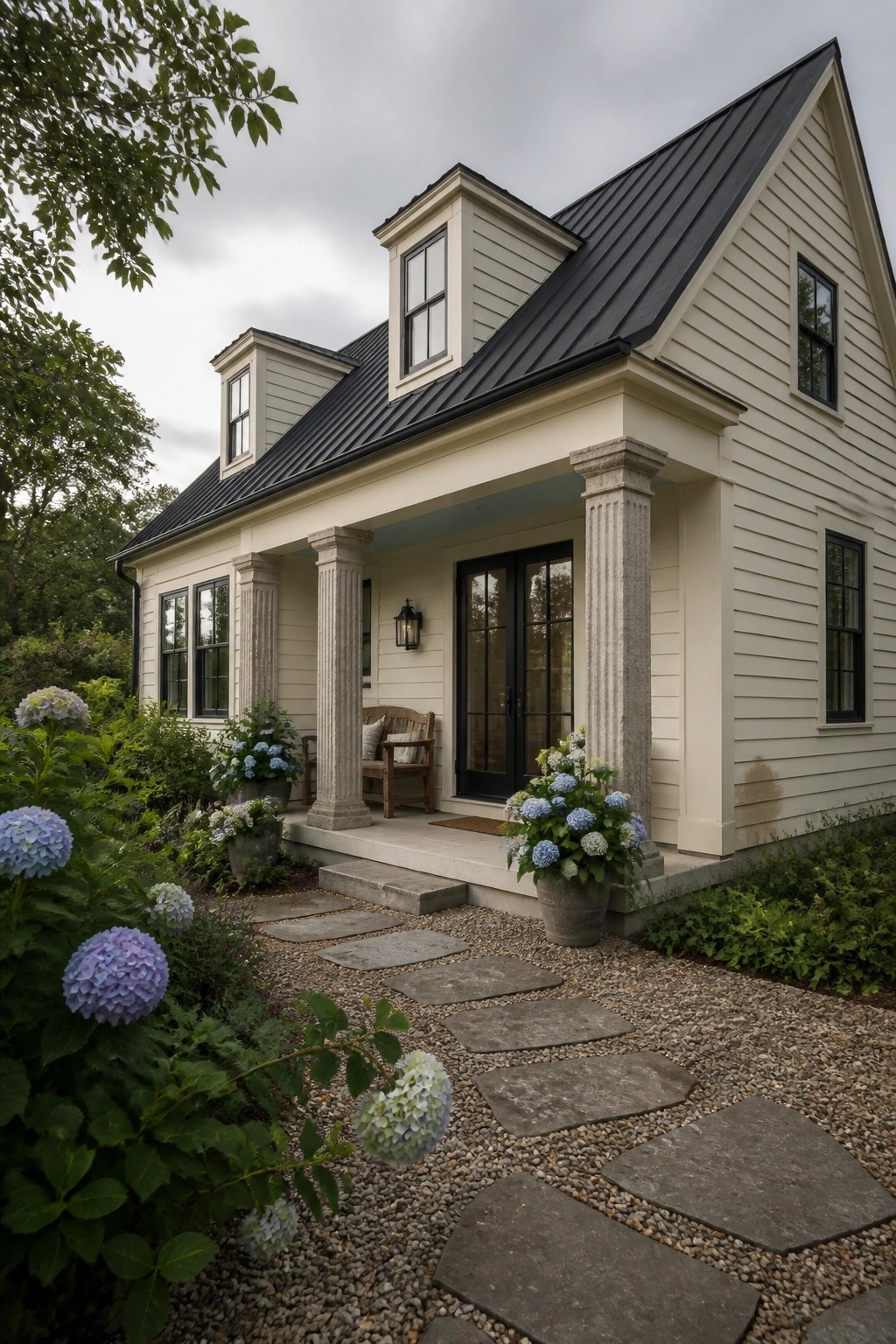 Warm cream siding on a modern farmhouse exterior with stone columns.