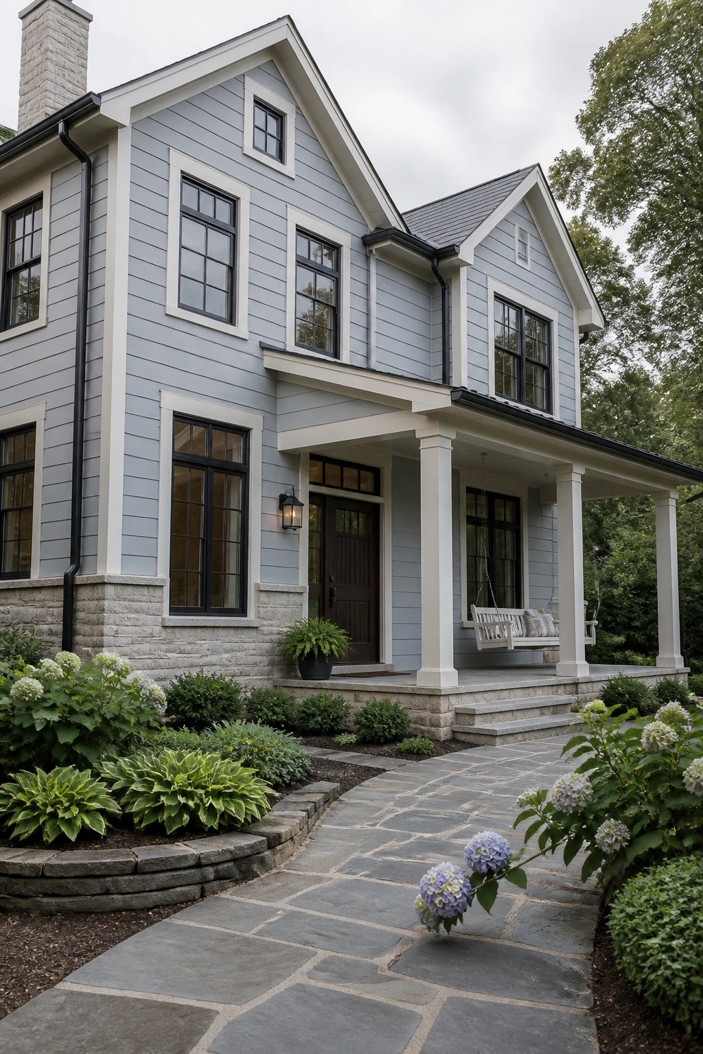 Light blue gray Hardie board siding on a modern farmhouse with white trim and a stone foundation.