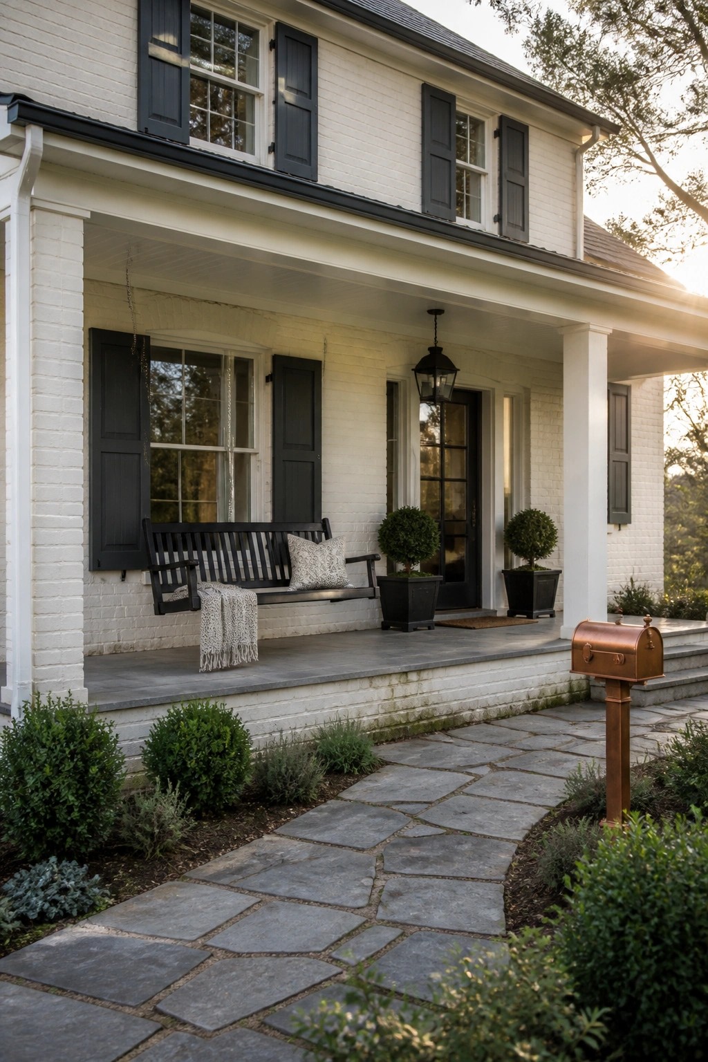 White painted brick on the front of a modern farmhouse with a stone walkway.