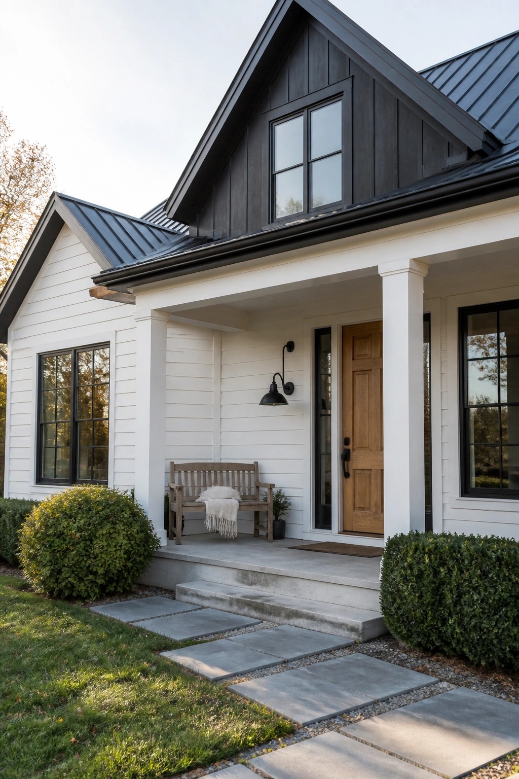 White siding on a modern farmhouse exterior with black trim and a dark metal roof.