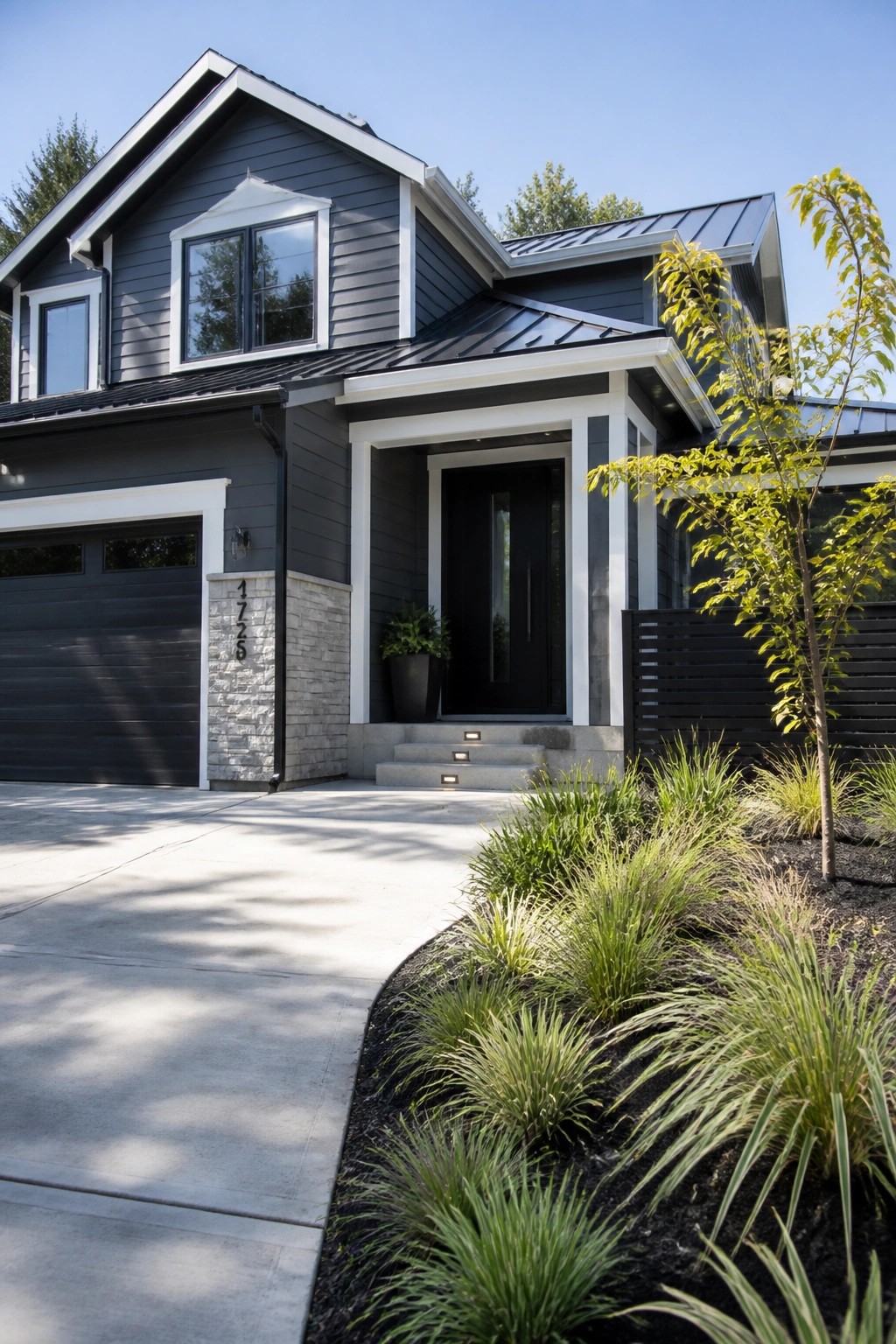 Dark charcoal gray siding on a modern farmhouse exterior with white trim.