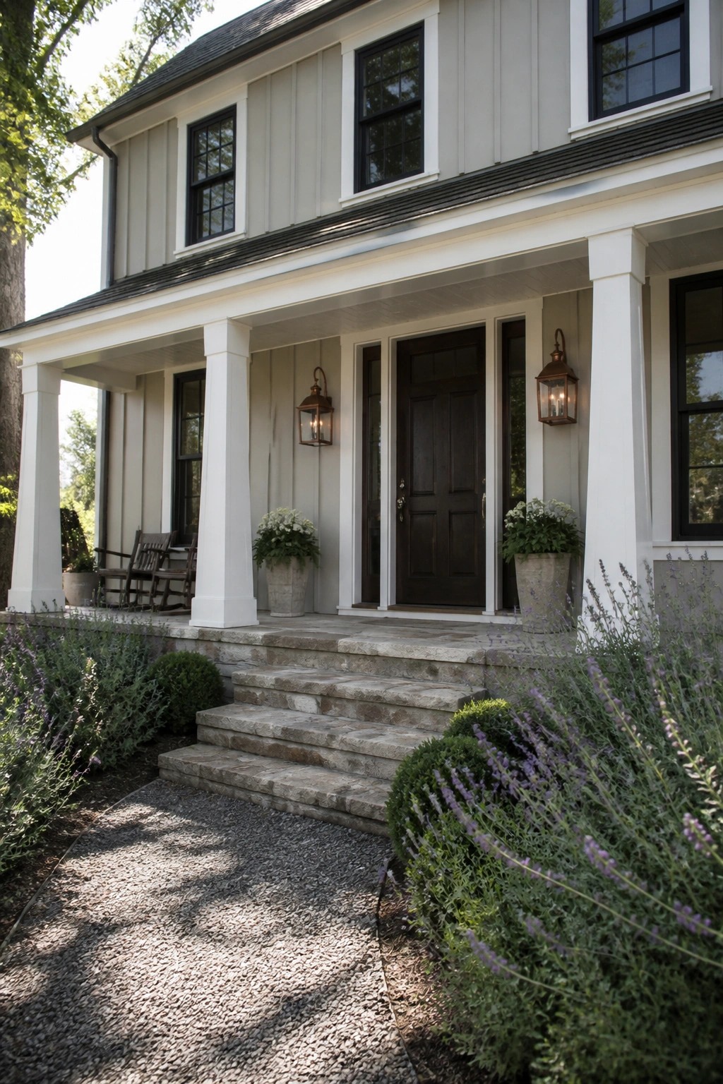 A house exterior painted in soft light gray siding with white trim and columns.