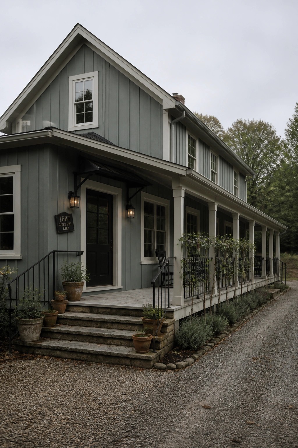 A modern farmhouse exterior with muted sage green siding and white trim.