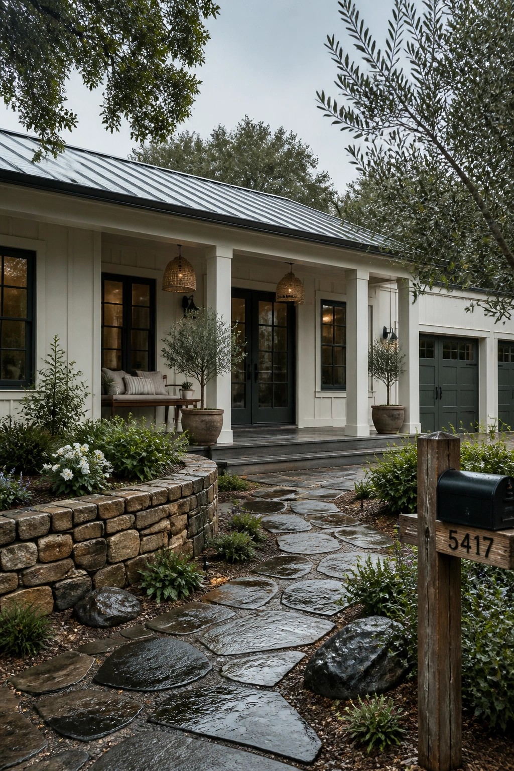 Modern farmhouse exterior with warm white siding along a stone path.