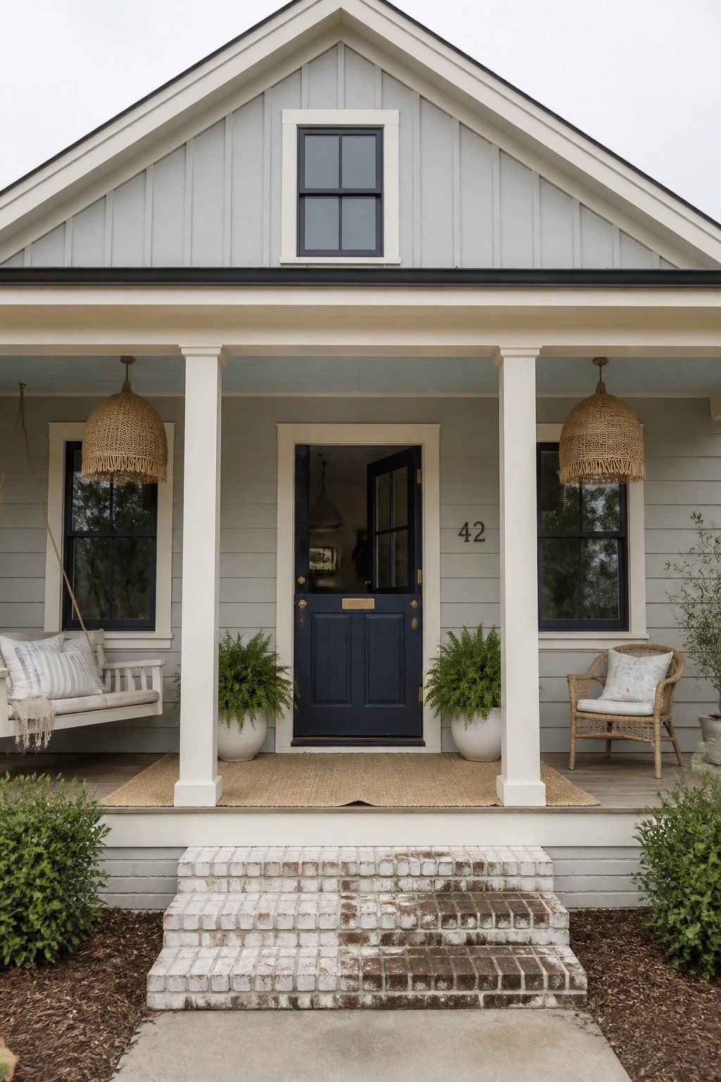 A modern farmhouse with light gray siding and white trim.