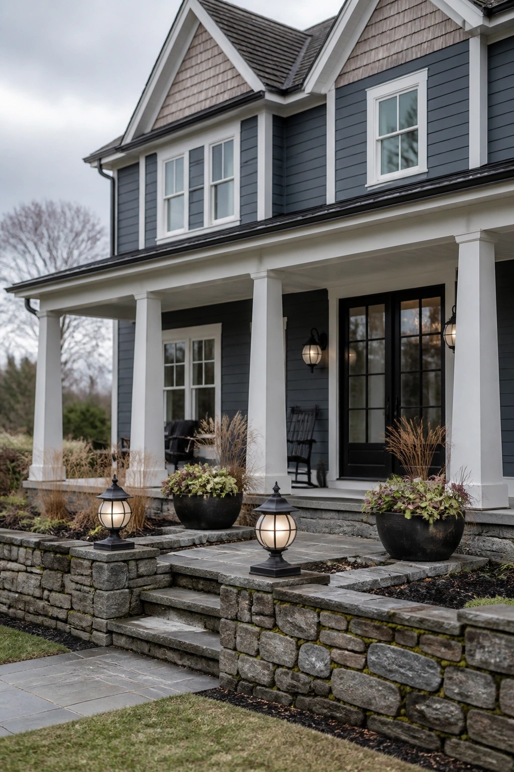 Dark blue two-story house with white porch columns and stone steps