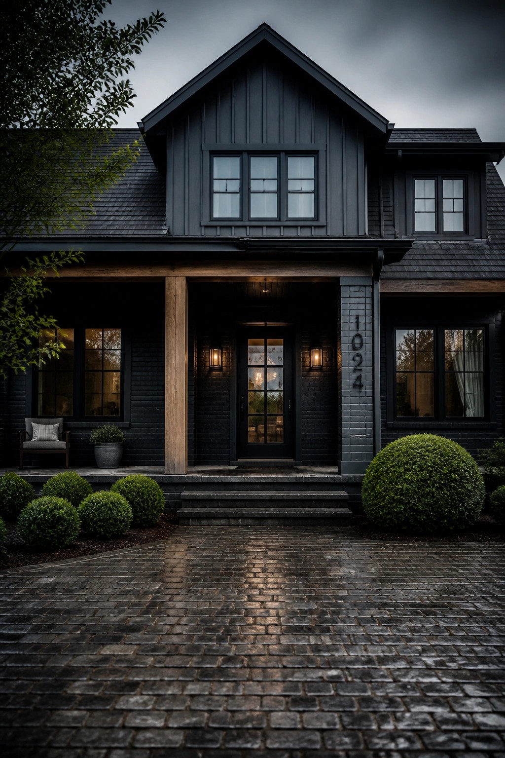 A modern farmhouse exterior with dark charcoal gray siding and wood accents.