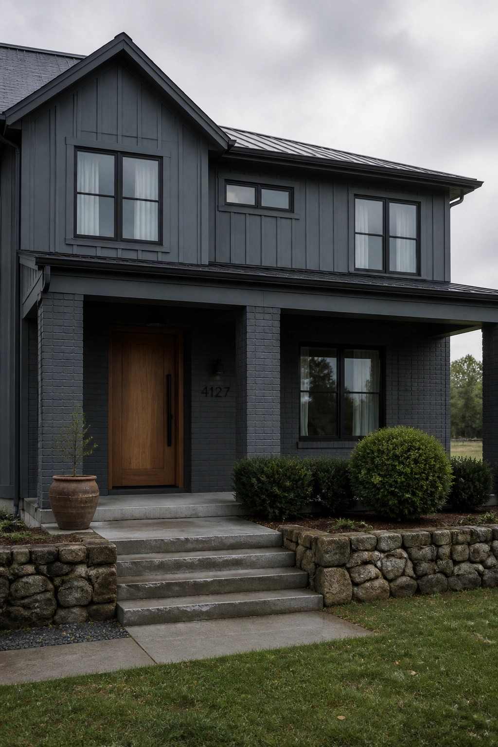 A modern farmhouse exterior painted in dark charcoal gray siding.
