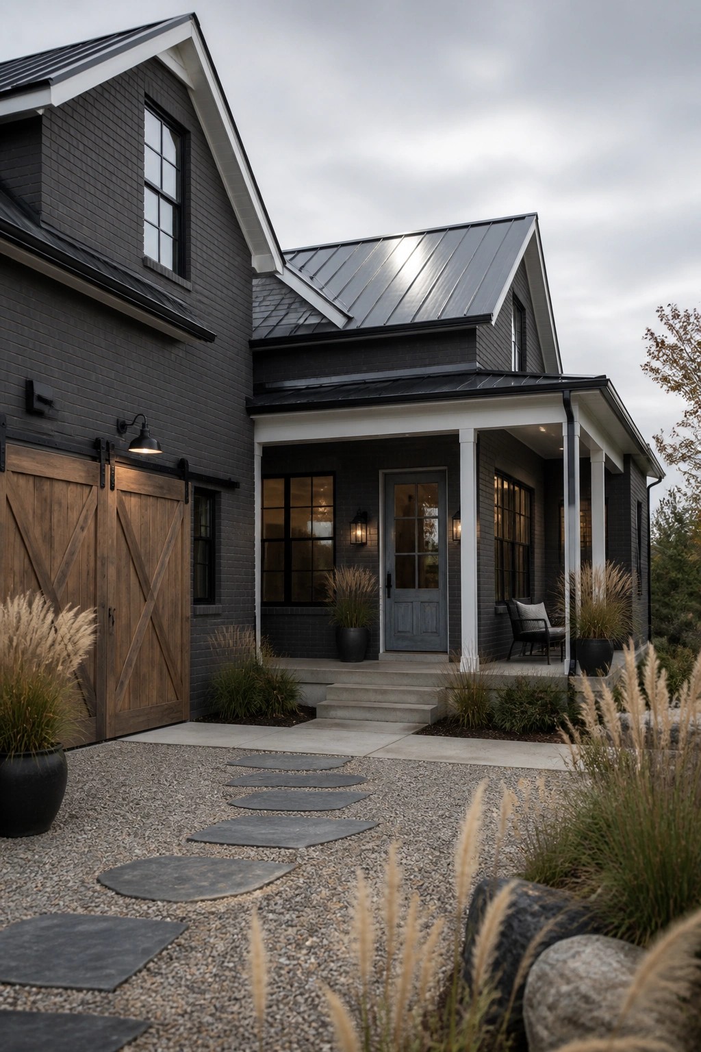 A modern farmhouse with dark charcoal gray painted brick and white trim.