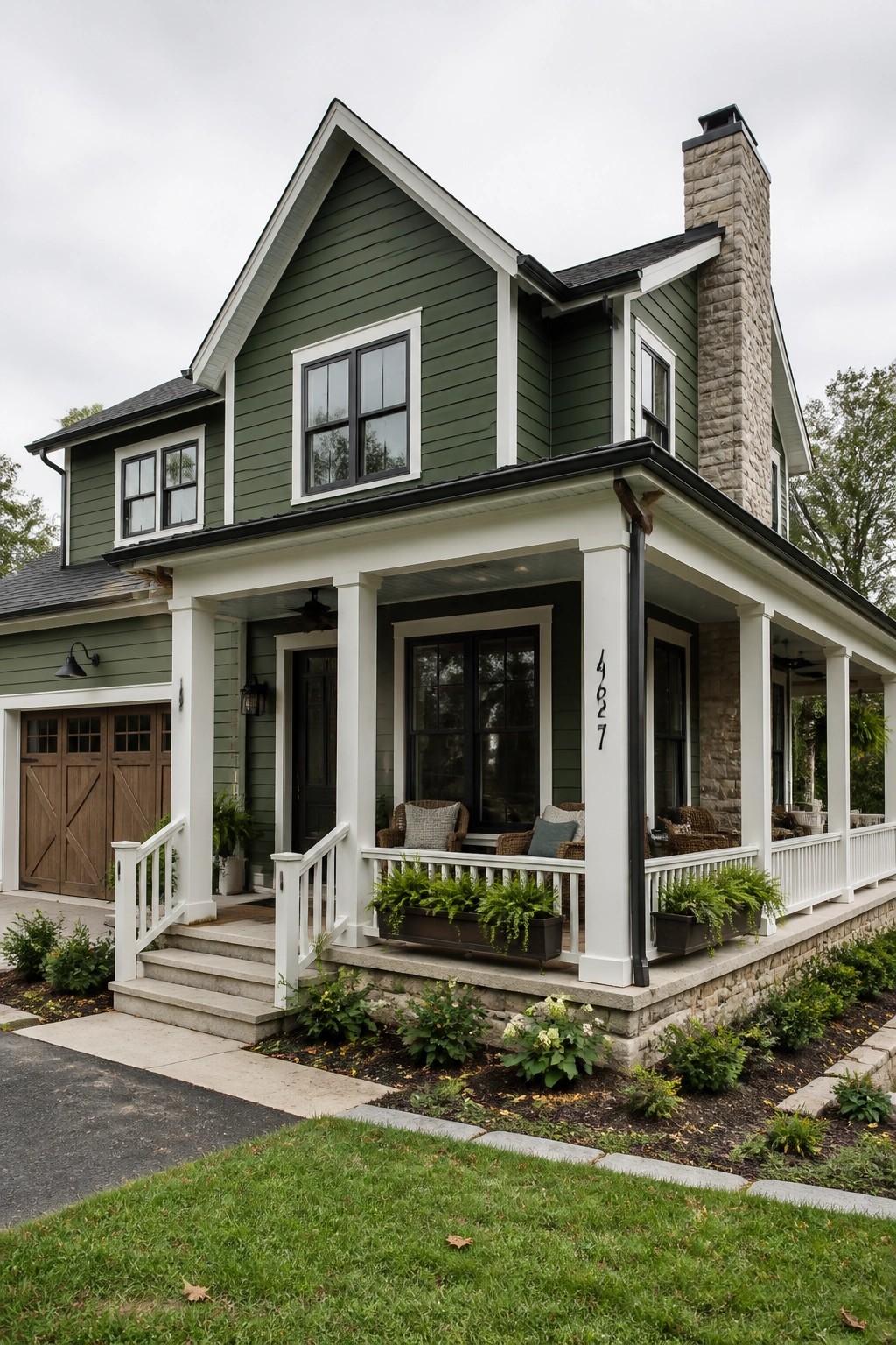 A modern farmhouse exterior with deep sage green siding and white trim.