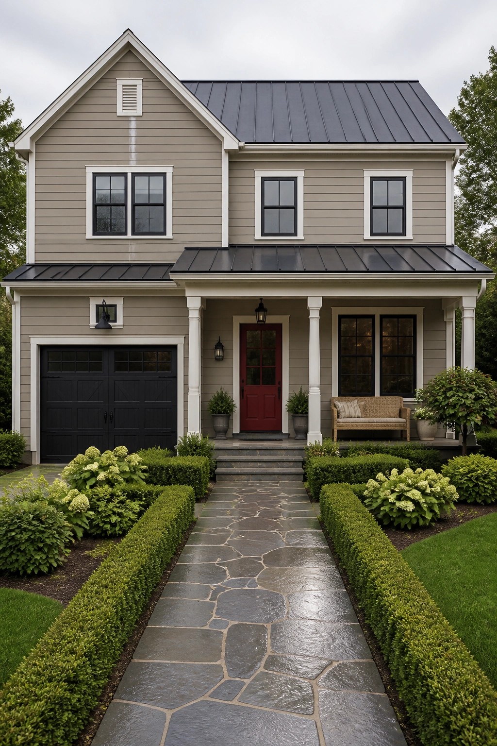 A two-story house with warm greige siding and black metal roofing.