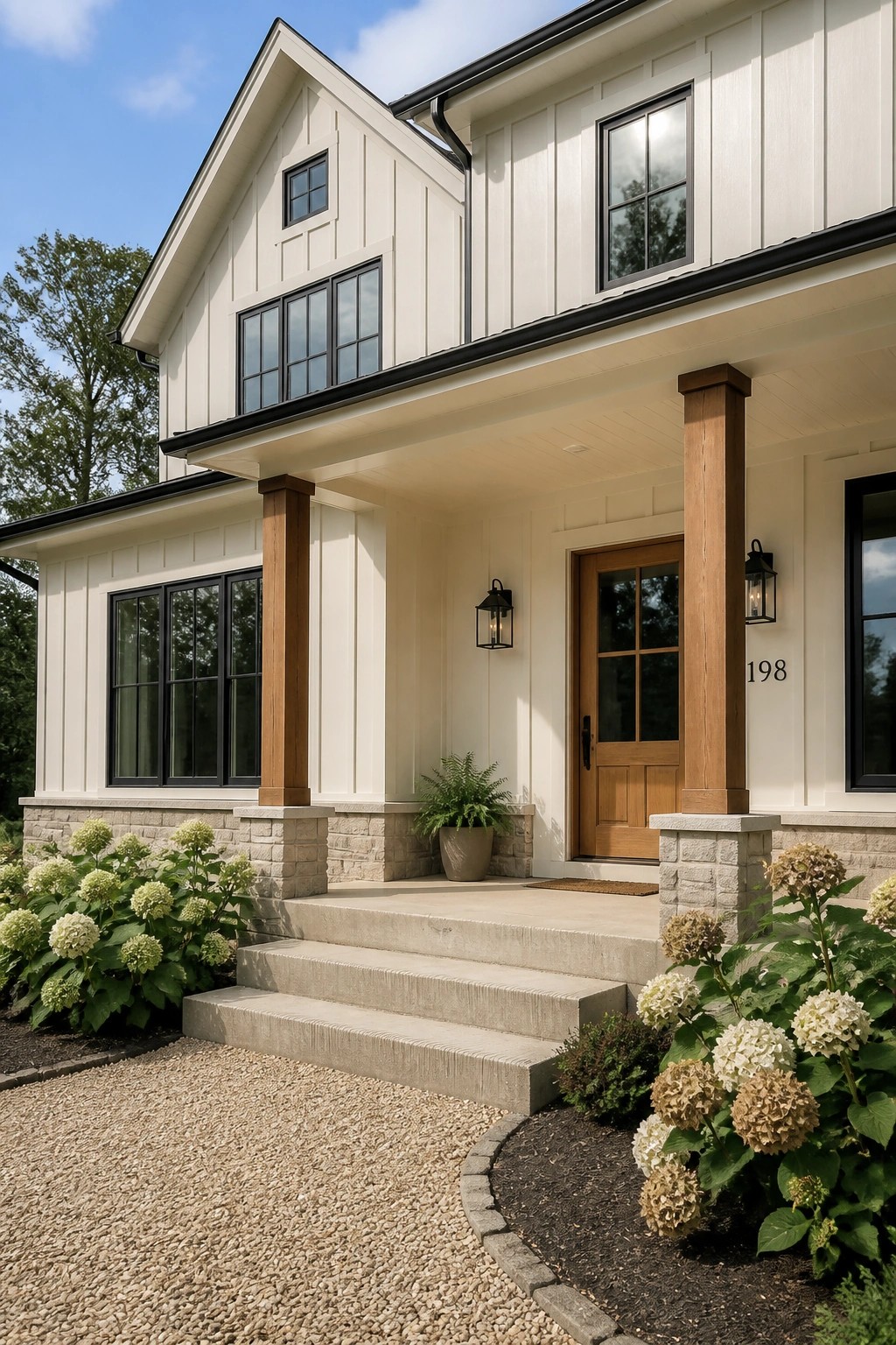 Modern farmhouse exterior with warm off-white siding and wood porch columns.