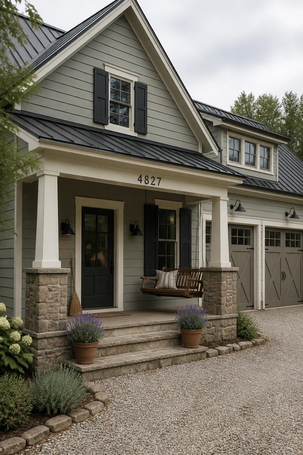 Light sage gray siding covers the exterior of a farmhouse with white trim and a gravel driveway.