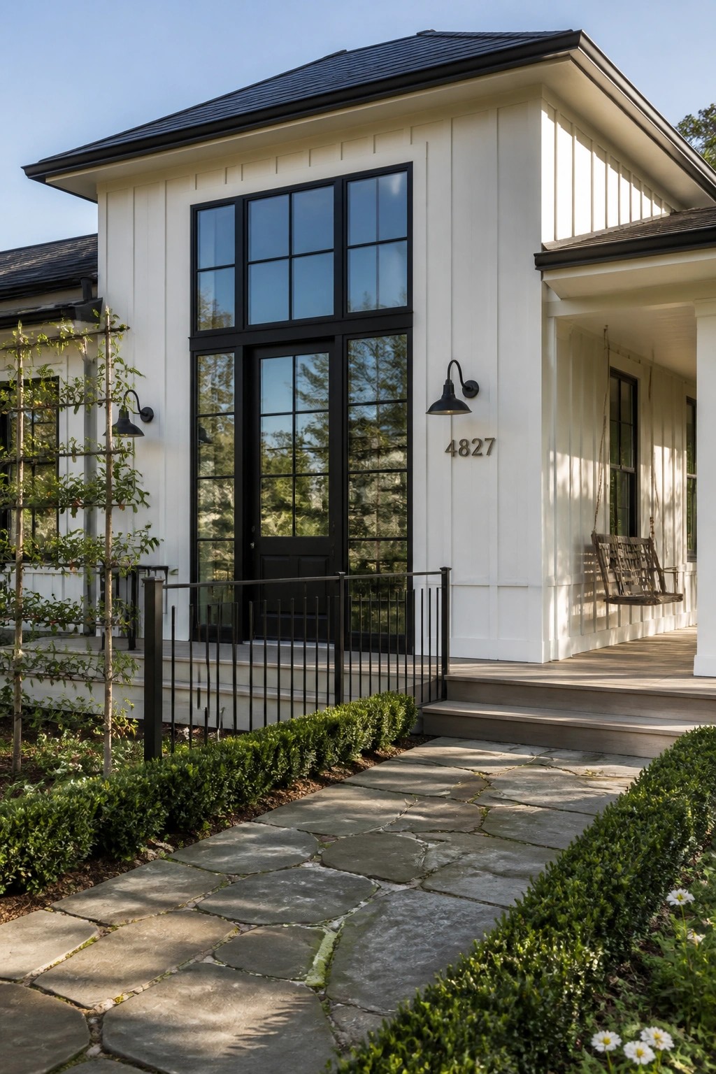 White siding on a modern farmhouse with black window frames and trim.