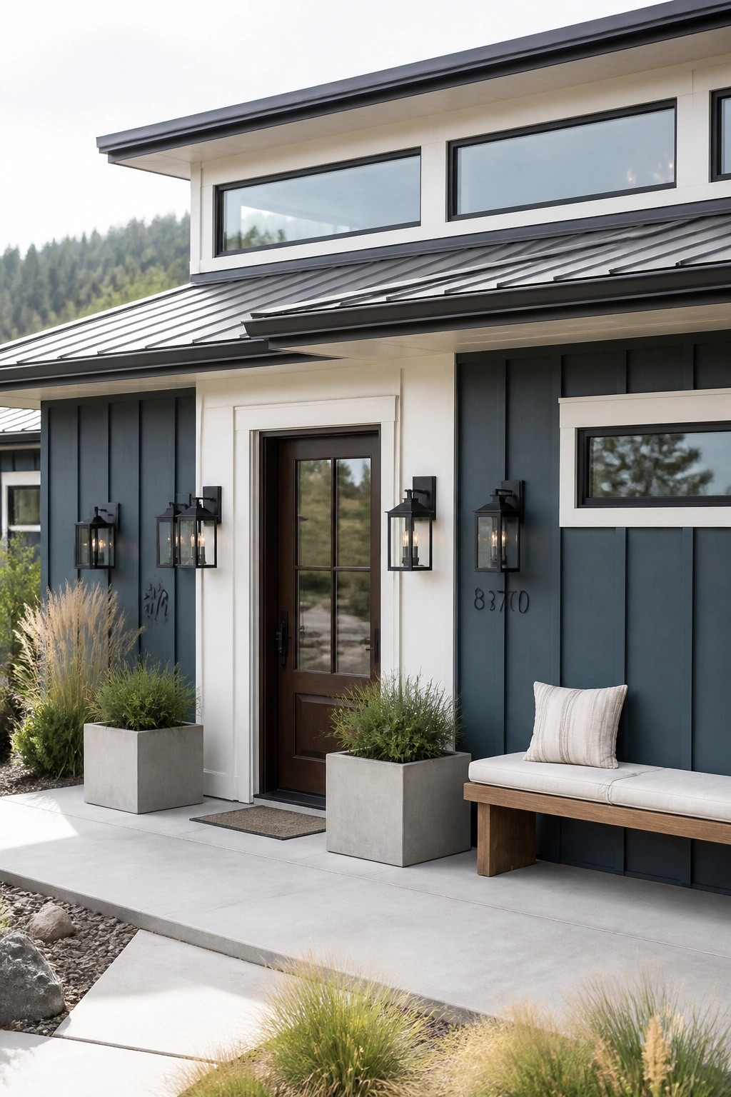 Modern farmhouse exterior with dark blue gray board and batten siding and white trim.