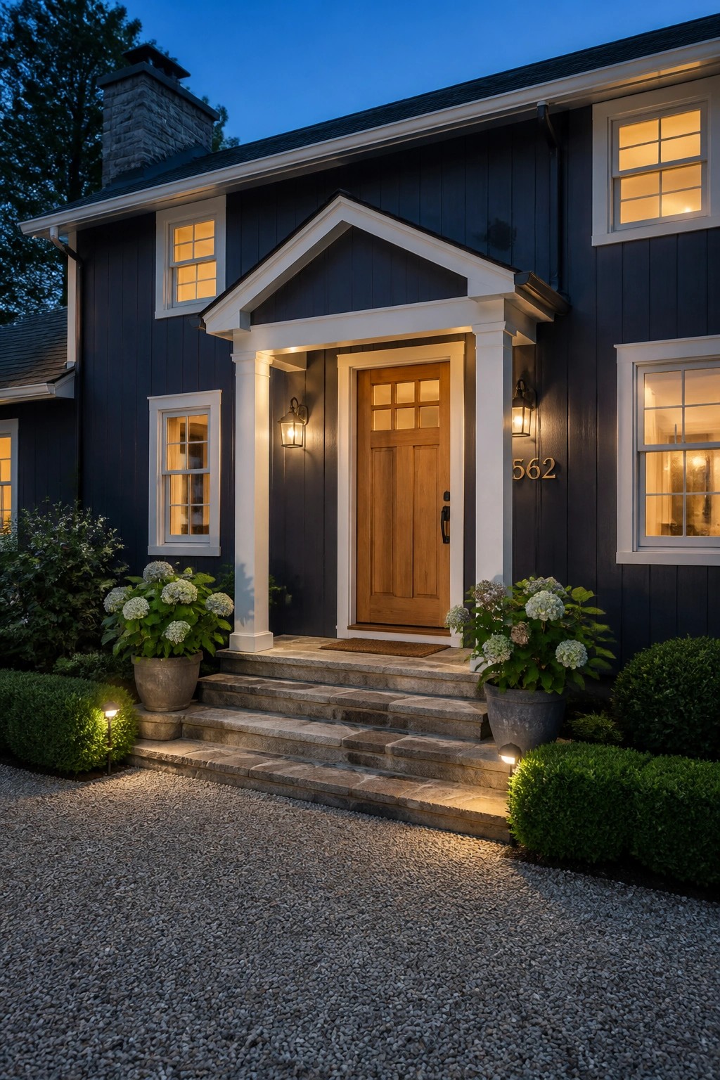 A modern farmhouse exterior painted in deep navy with white trim and a wood door.