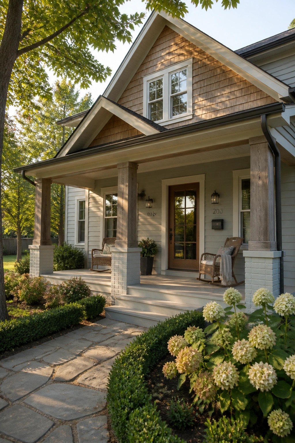 A modern farmhouse exterior with soft sage green siding and wood porch columns.